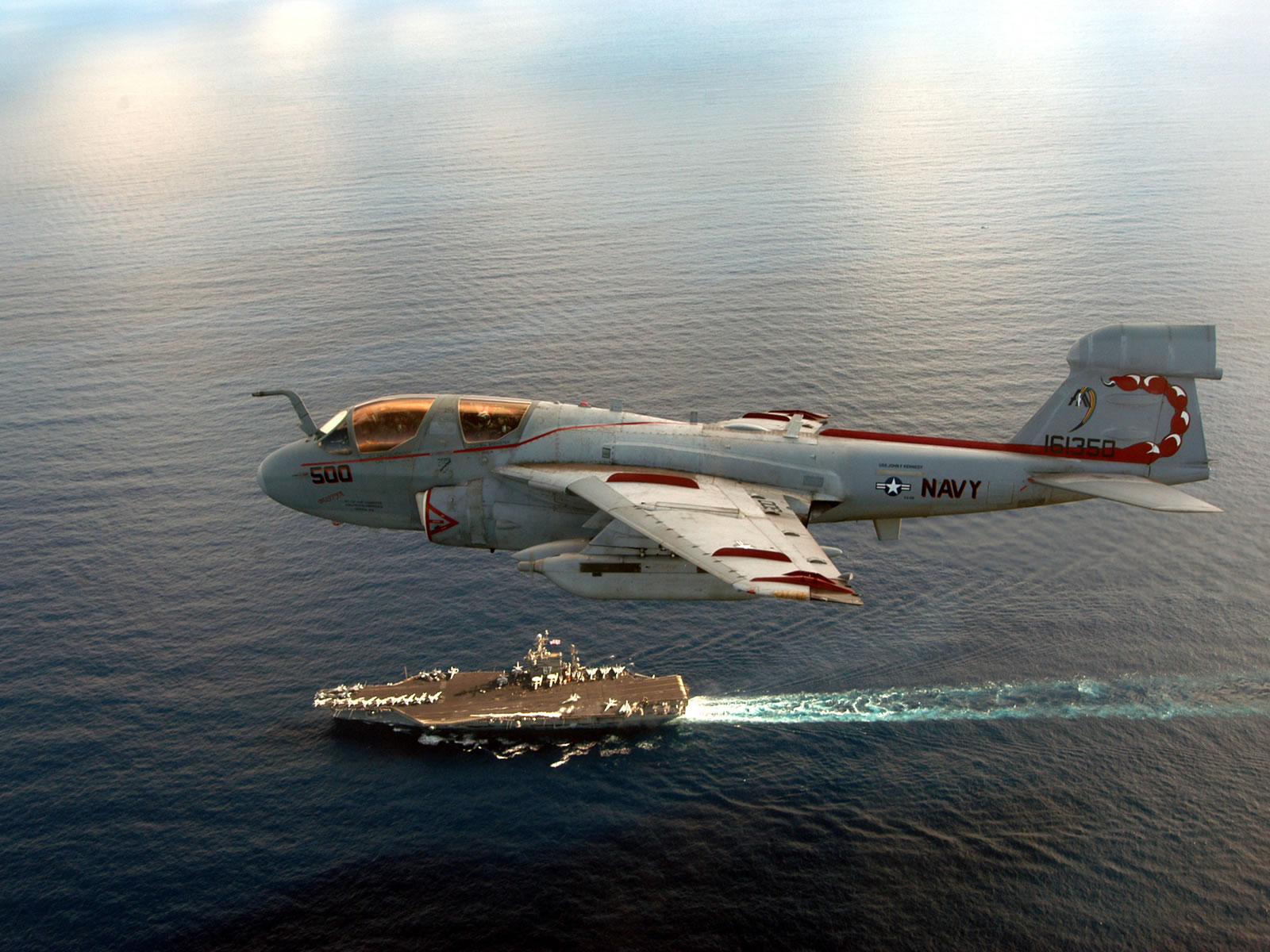 Northrop Grumman EA-6B Prowler jet flies over a Navy aircraft carrier HD Wallpaper