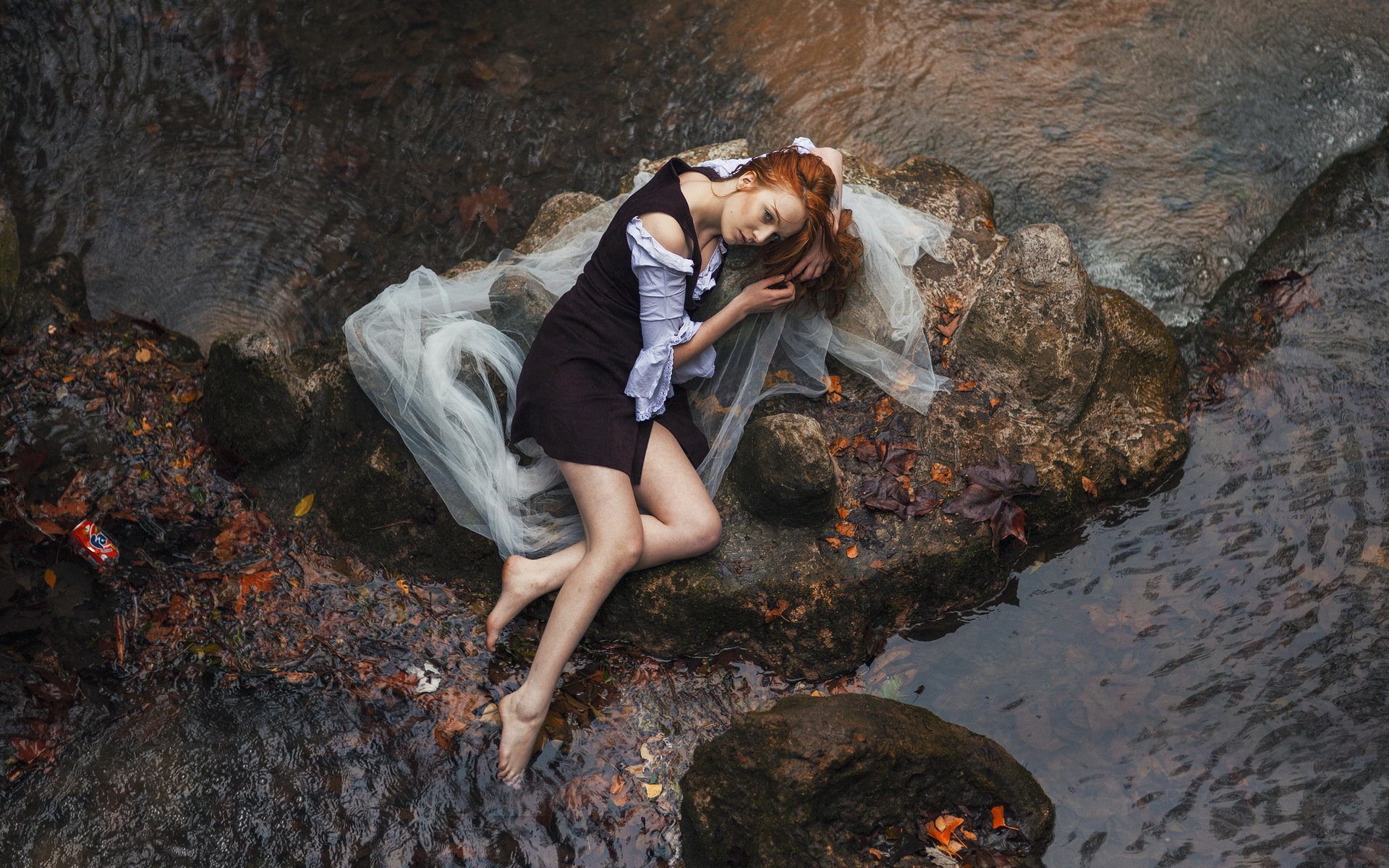 Woman lying on rocks in a stream HD Wallpaper