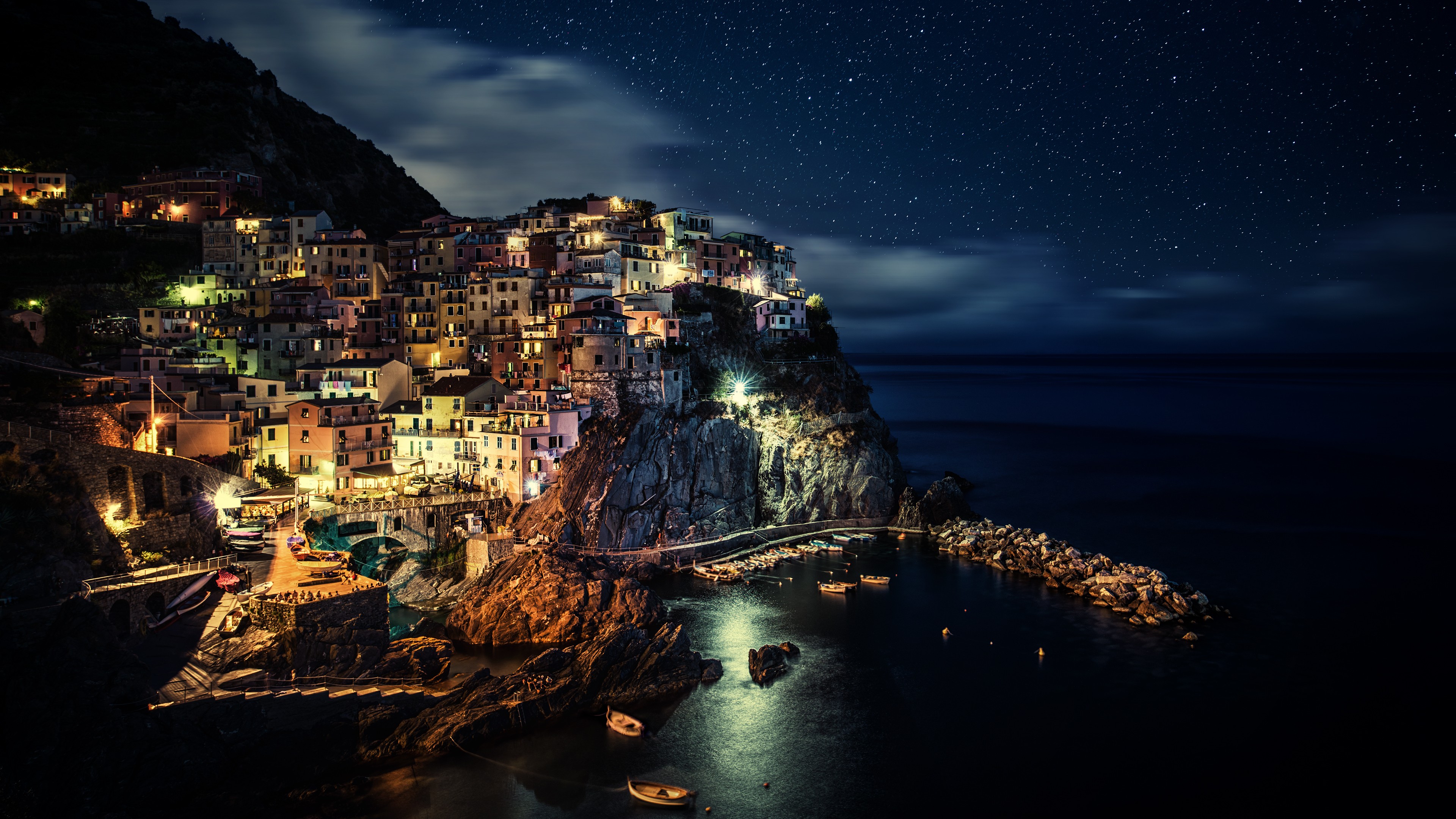 Coastal village at night under starry sky HD Wallpaper