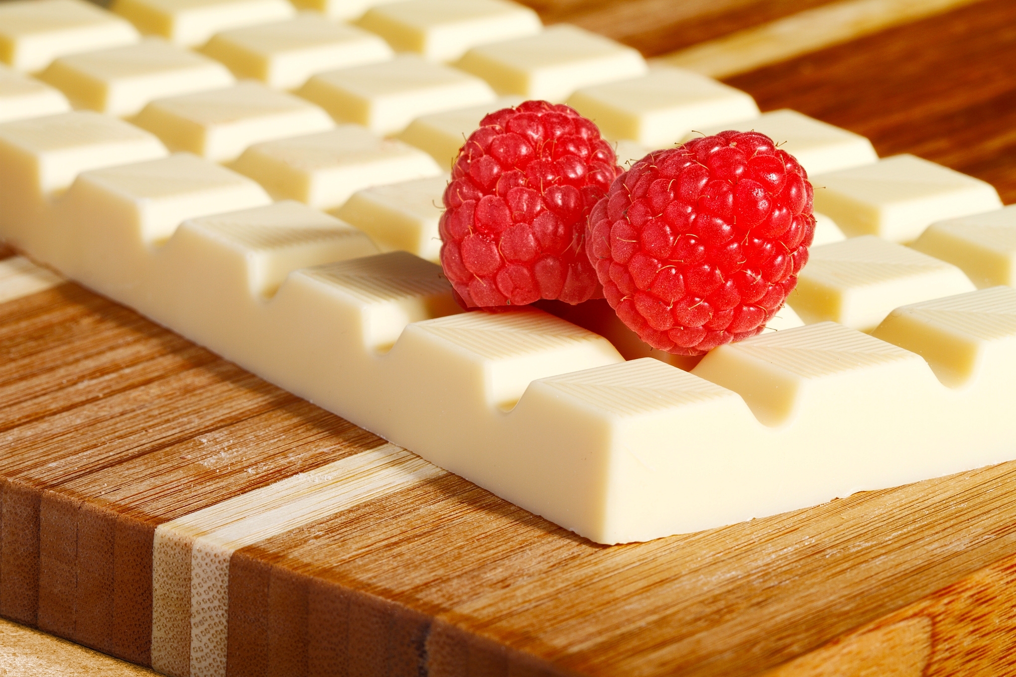 White chocolate bar with raspberries on a wooden board HD Wallpaper