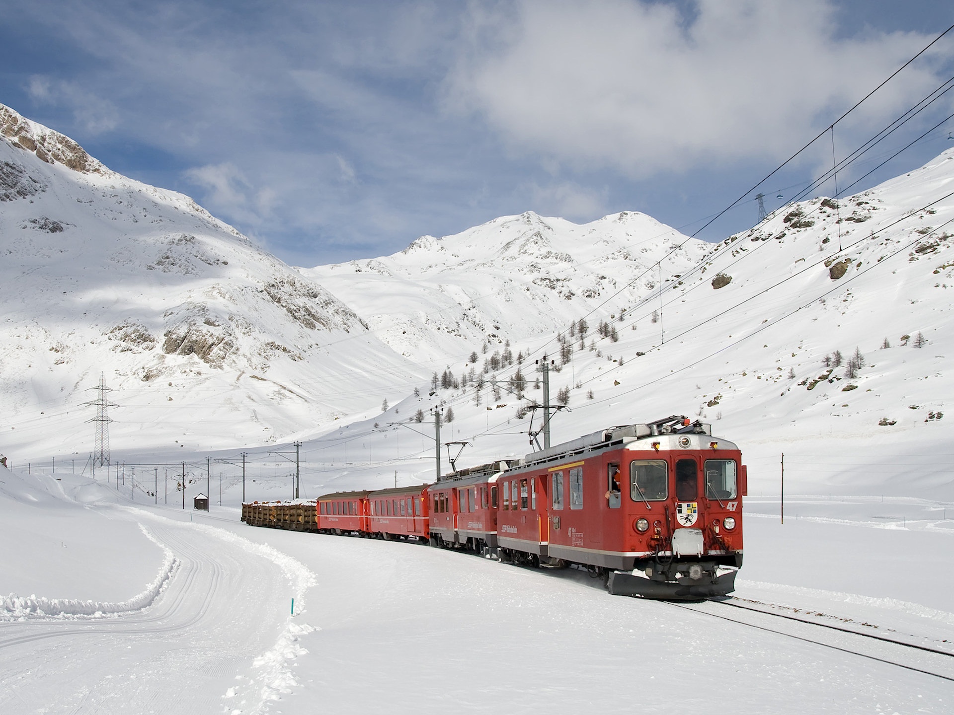 Red electric train in a snowy mountain landscape HD Wallpaper