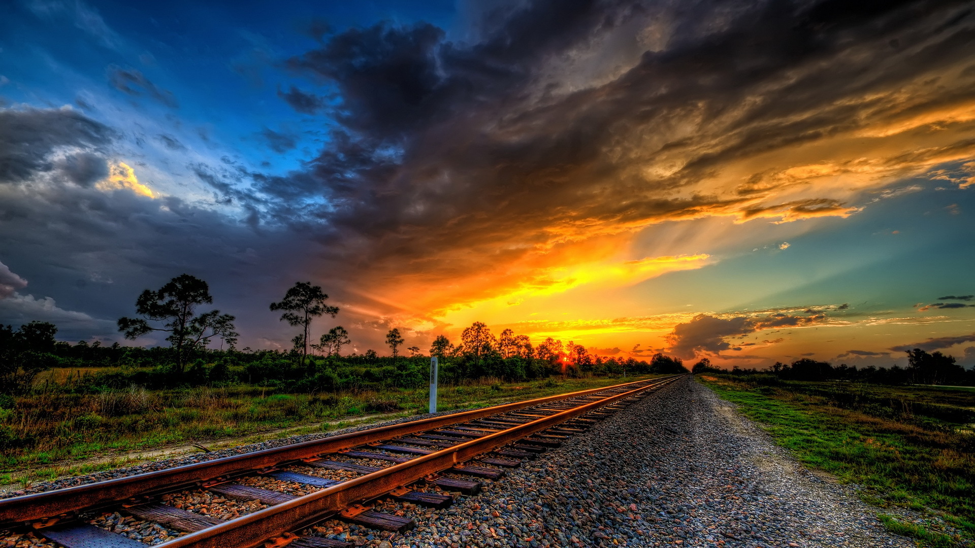 Railroad tracks at sunset with dramatic clouds HD Wallpaper