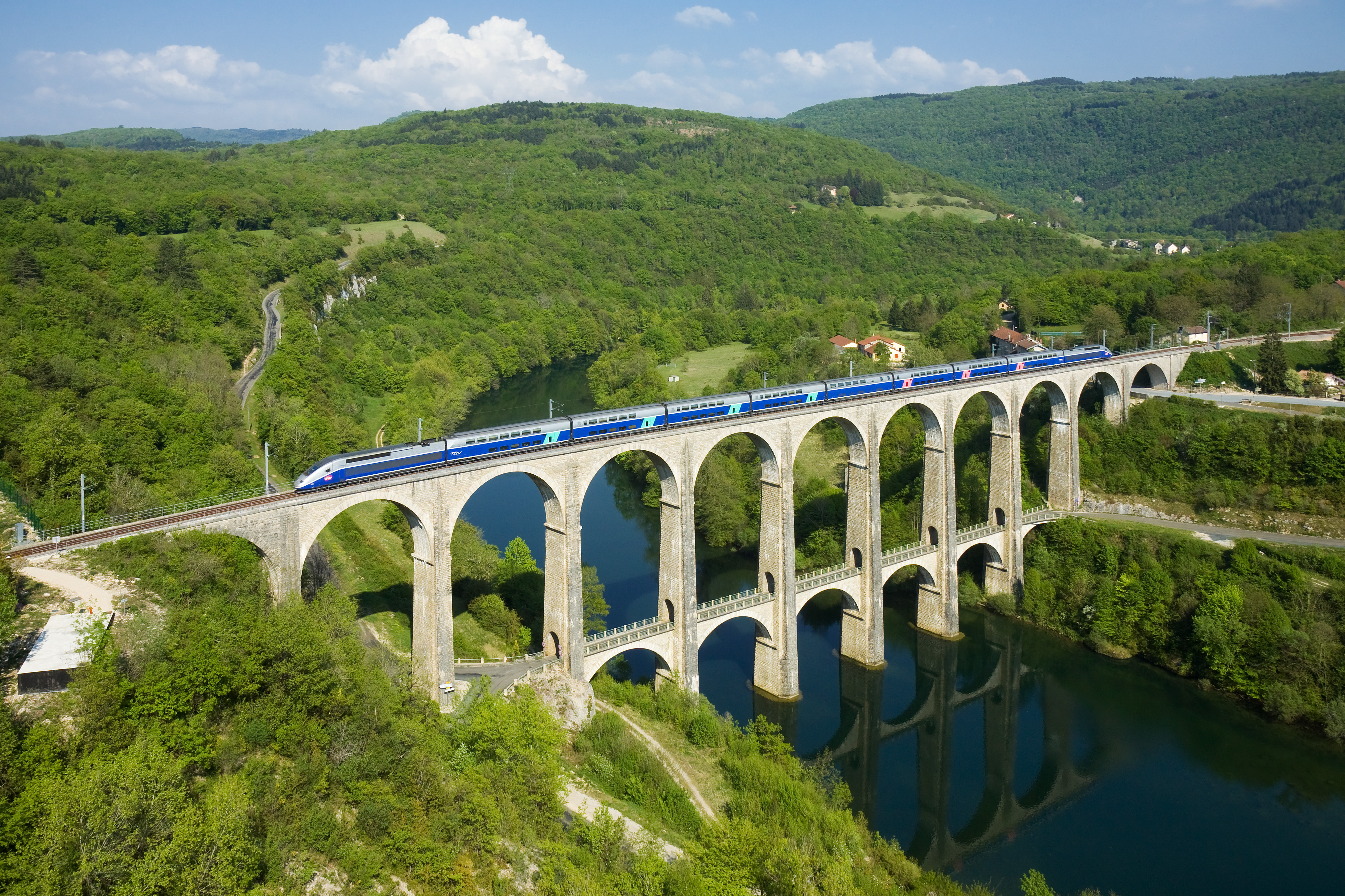 Train on a viaduct over a river in a green valley HD Wallpaper