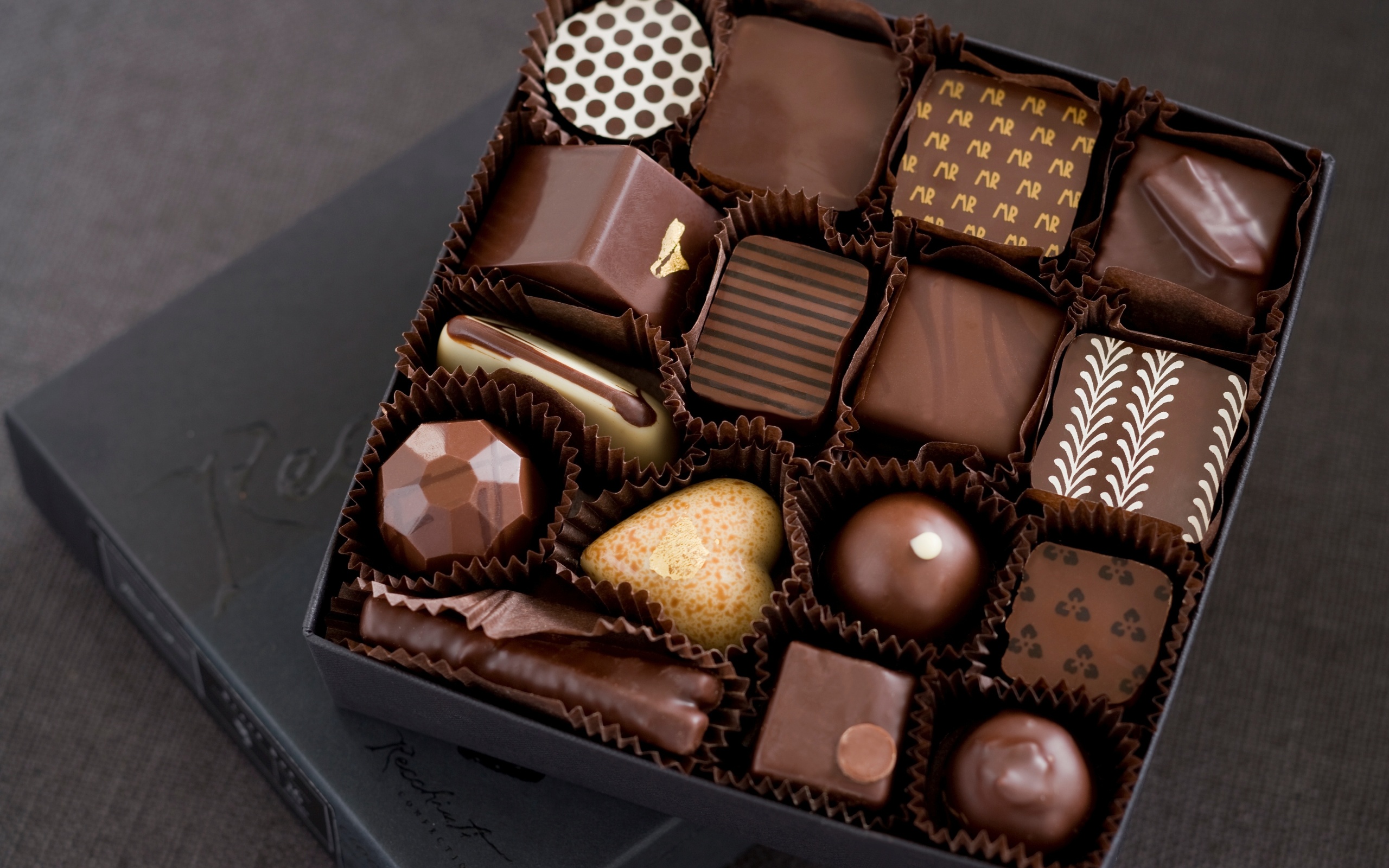 Assortment of gourmet chocolates in a box HD Wallpaper