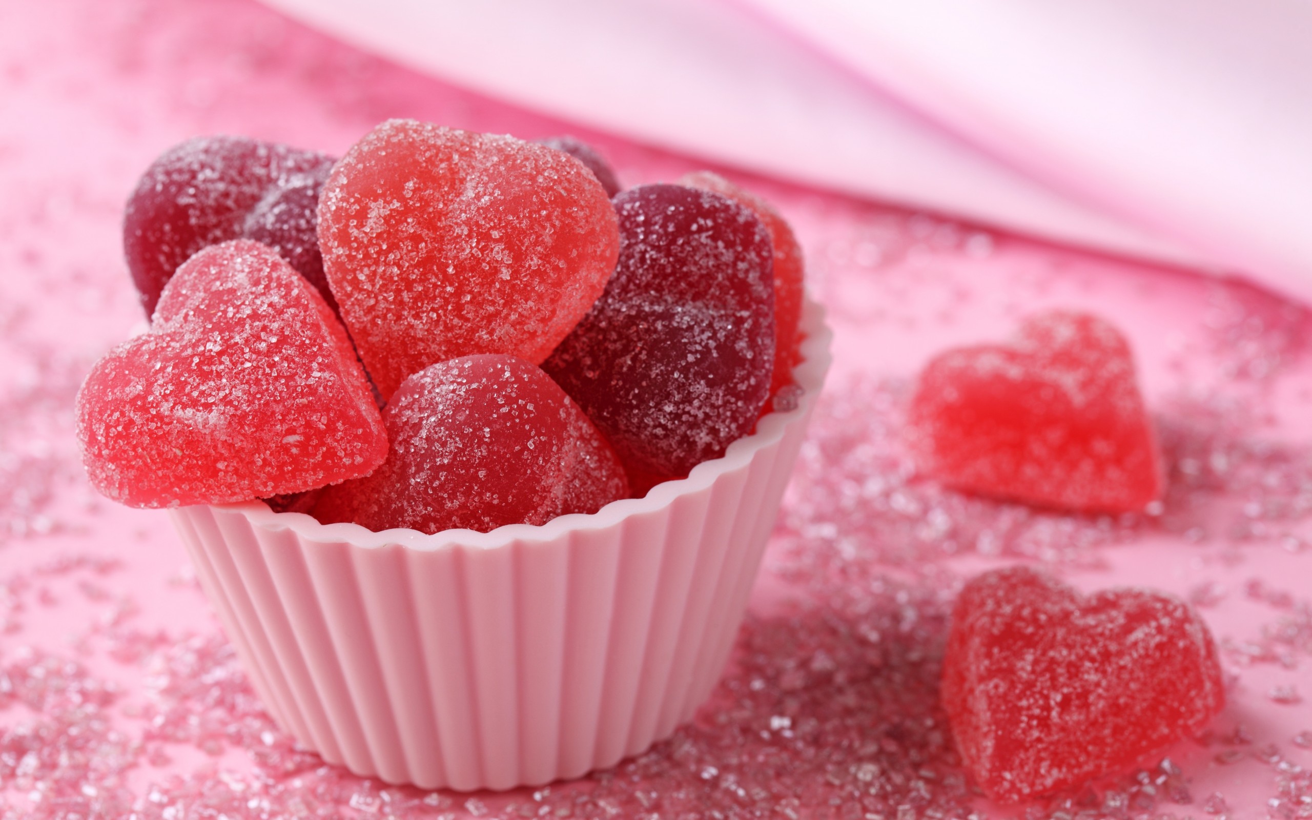Heart-shaped candies in a pink cupcake liner HD Wallpaper