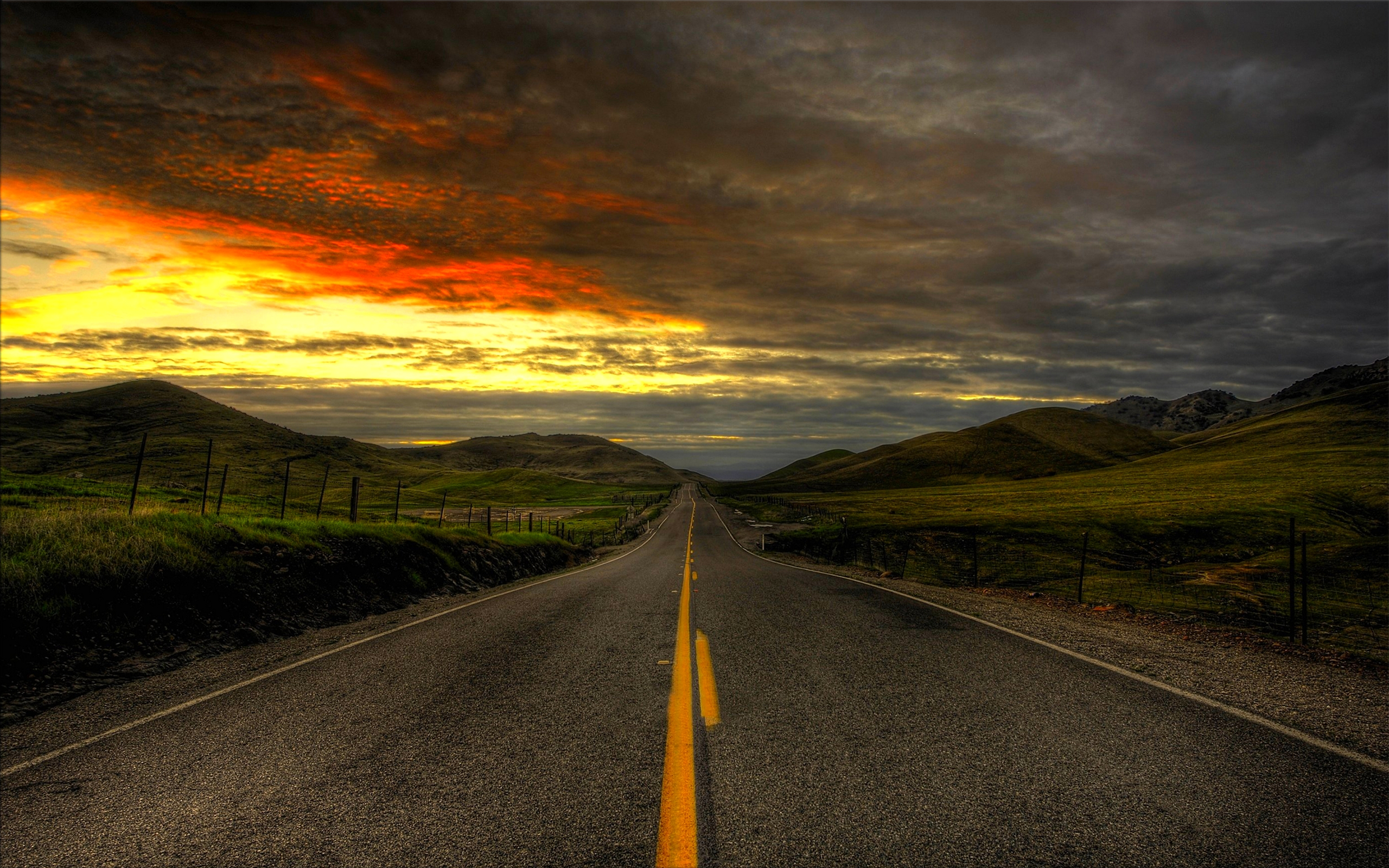 Road through rolling hills at sunset HD Wallpaper