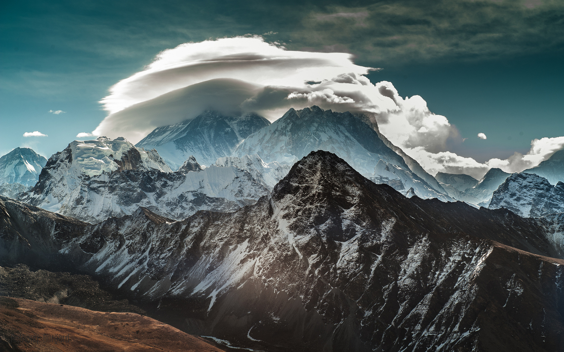 Snow-capped mountains under a cloudy sky HD Wallpaper