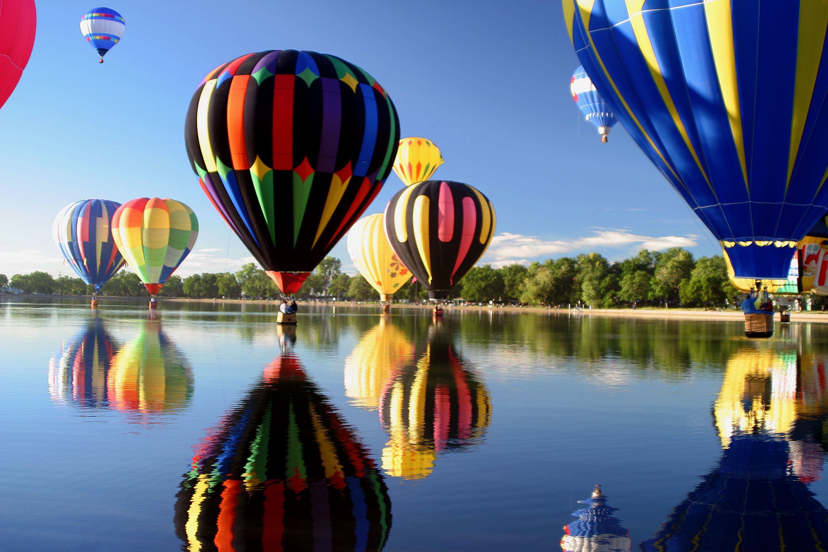Hot air balloons reflected in a lake HD Wallpaper
