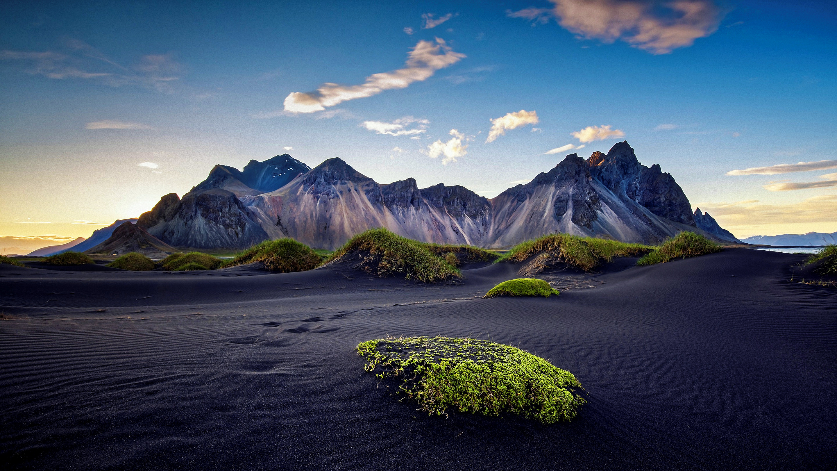 Black sand desert with mountains and grass HD Wallpaper