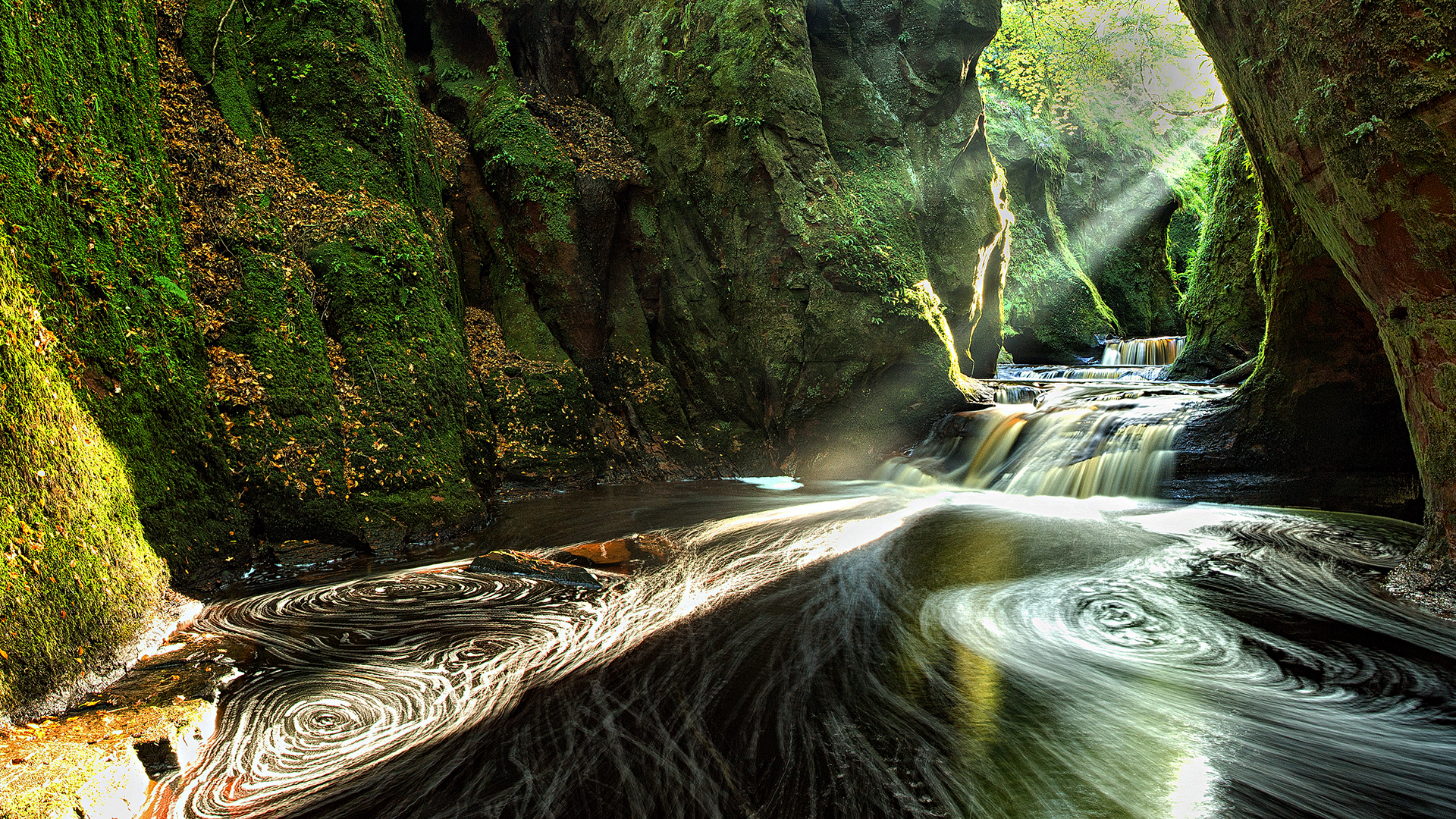 Sunbeams in a mossy canyon with a waterfall HD Wallpaper