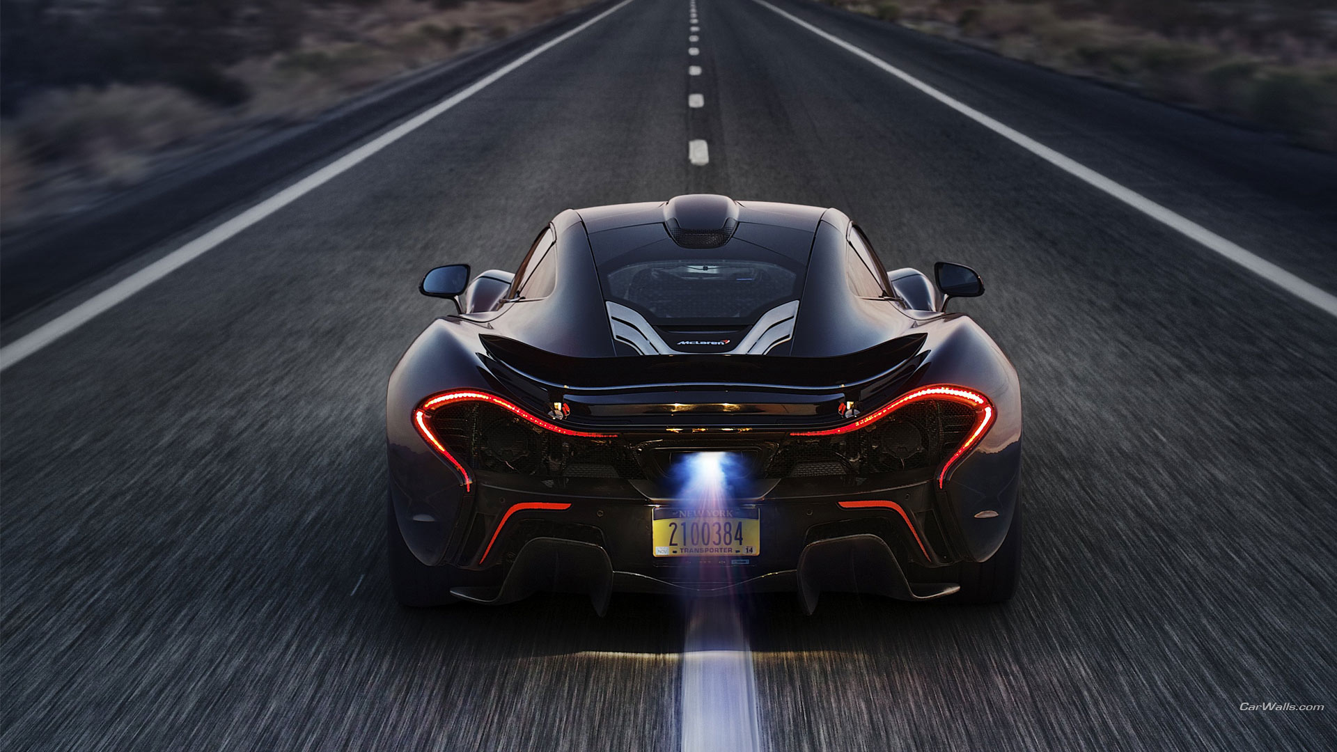 McLaren P1 driving on a road HD Wallpaper