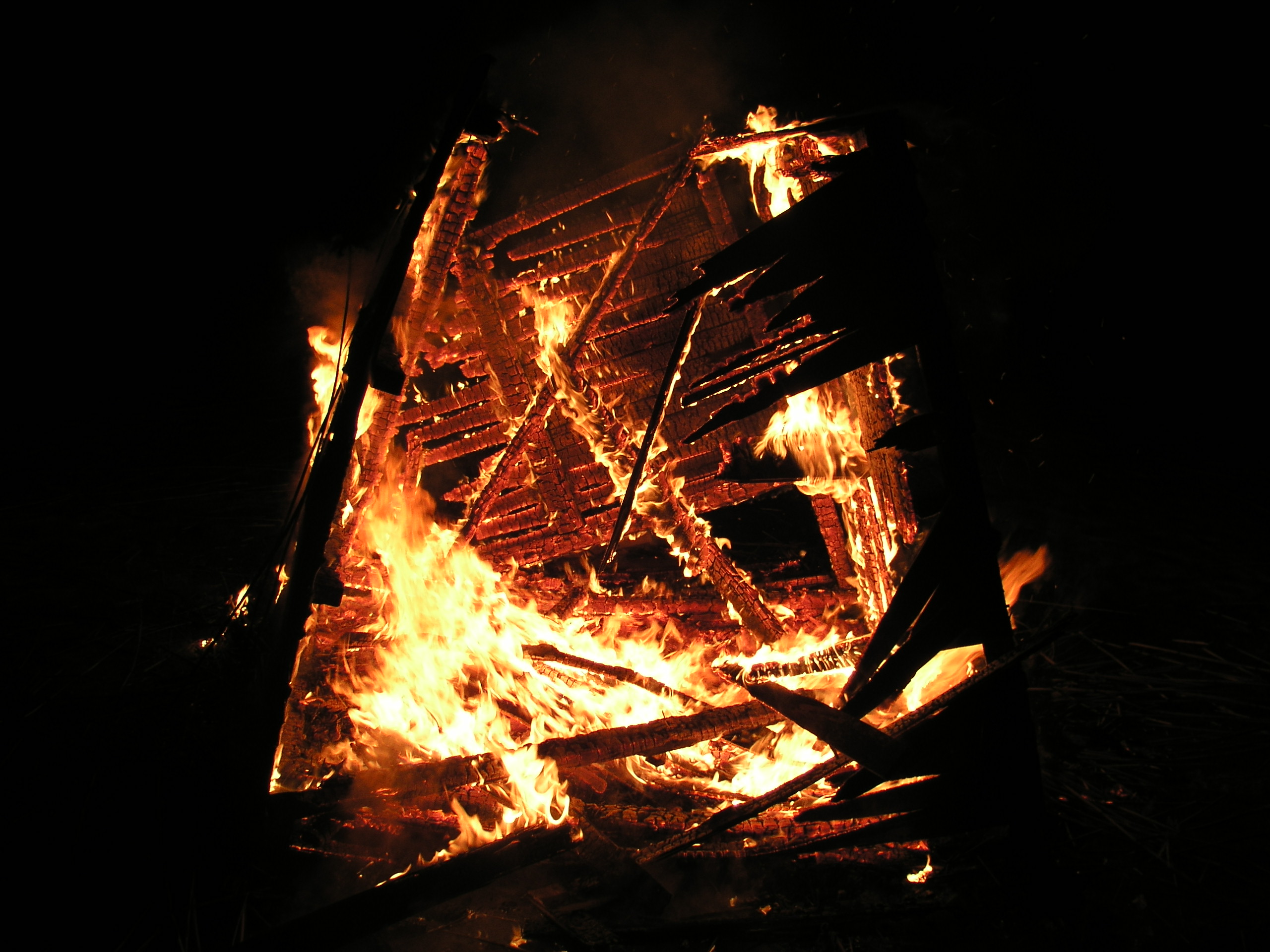 Structure engulfed in flames at night HD Wallpaper