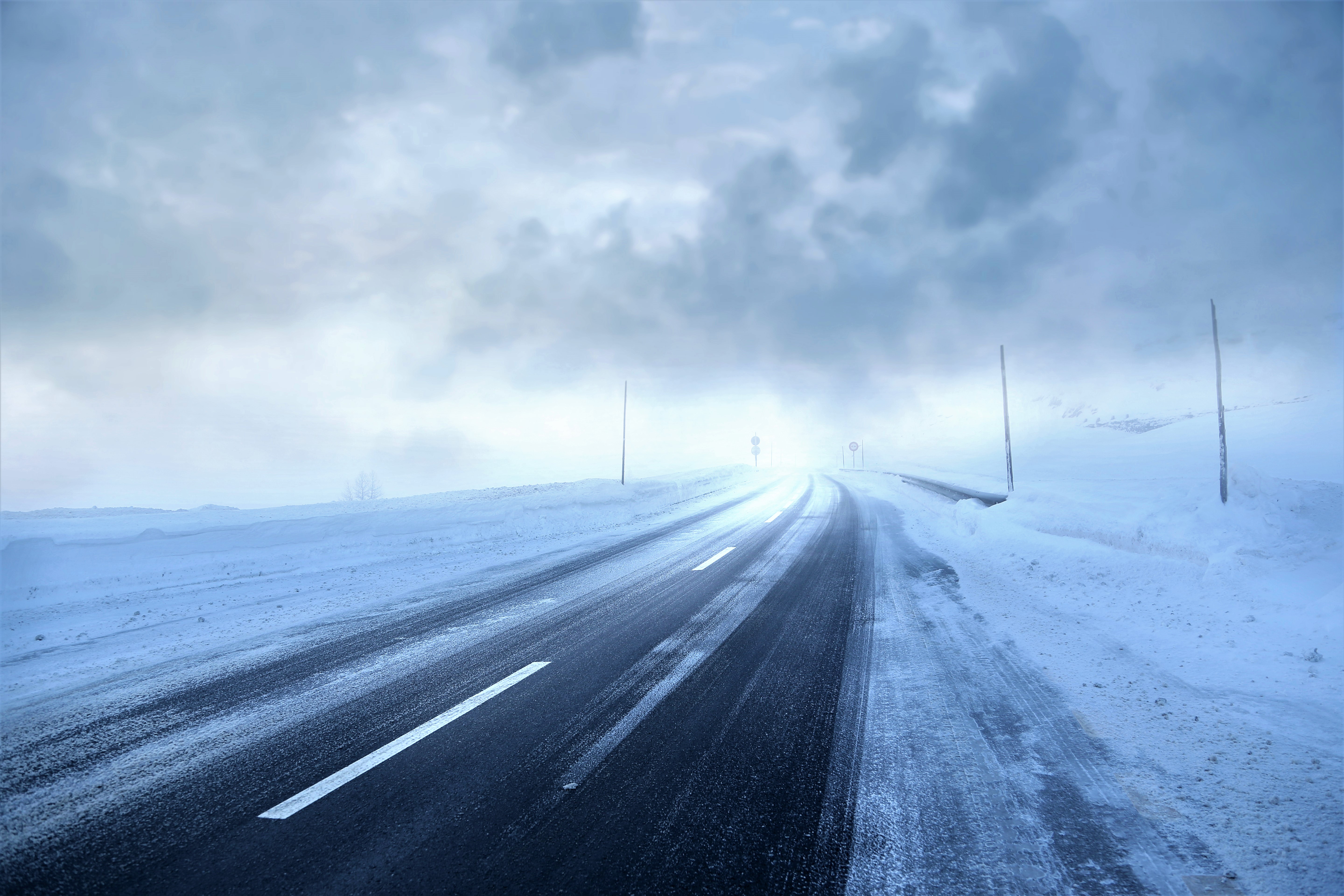 Road covered in snow during a winter storm HD Wallpaper