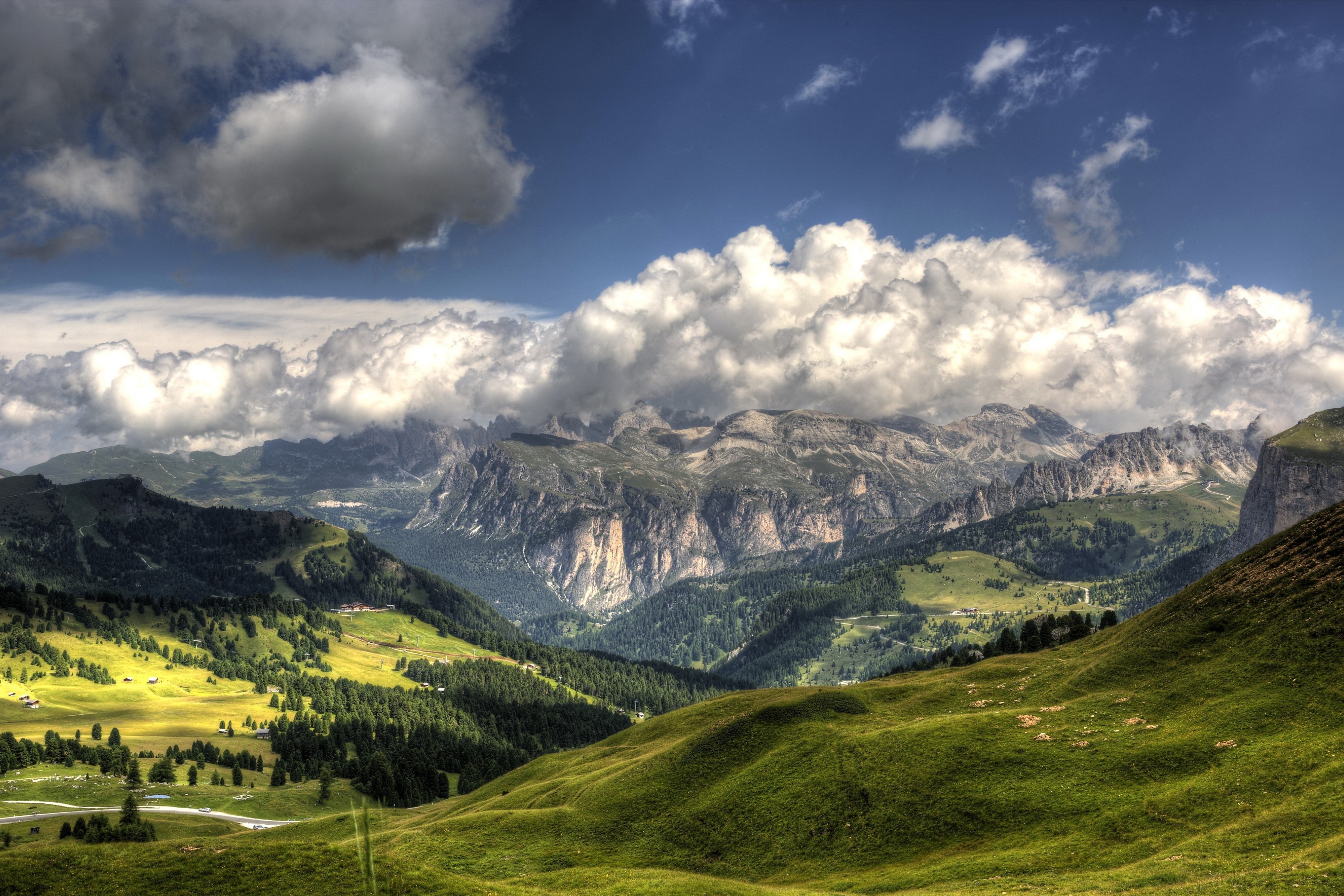 Green hills and mountains under a cloudy sky in Italy HD Wallpaper