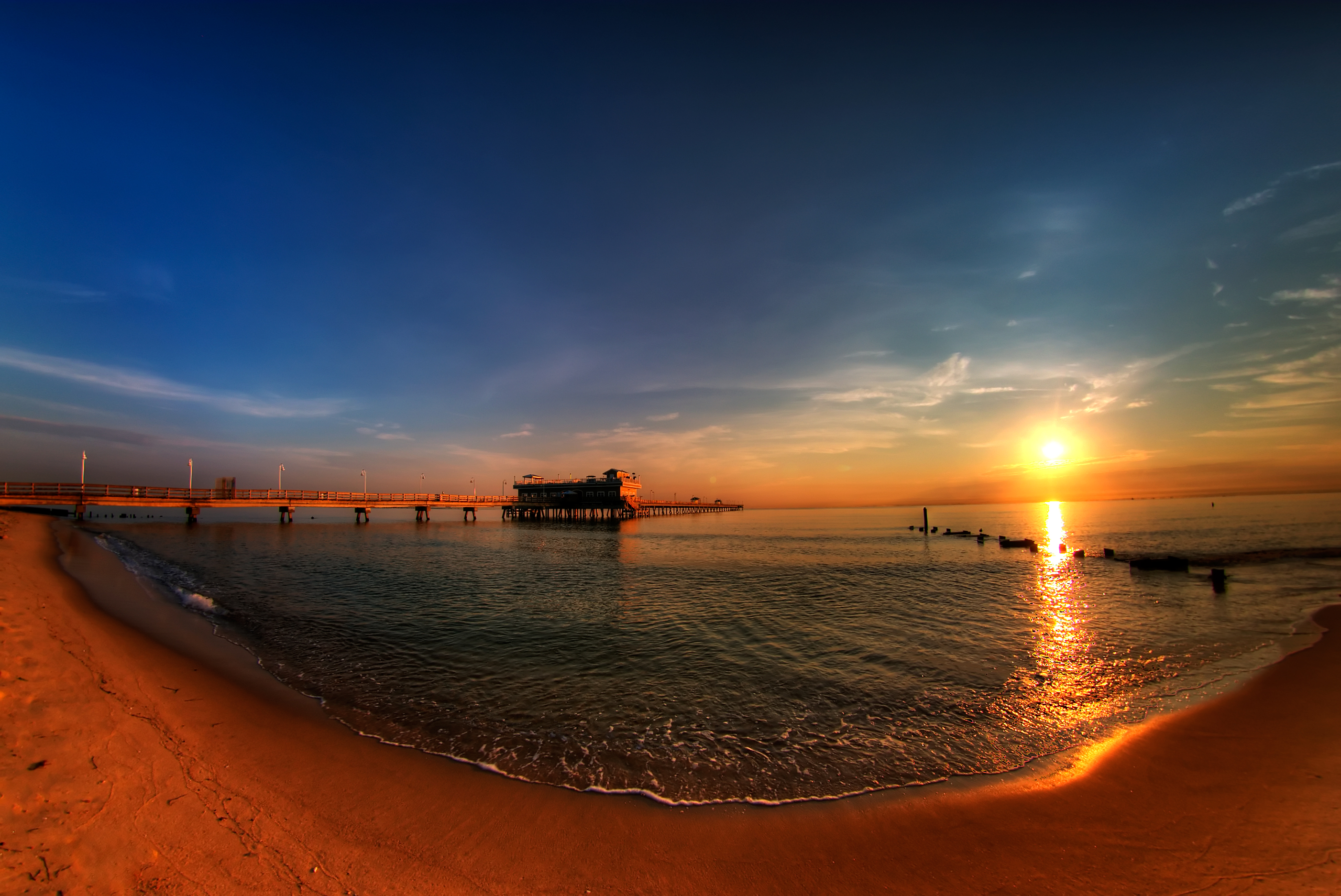 Sunset over the ocean with a pier HD Wallpaper