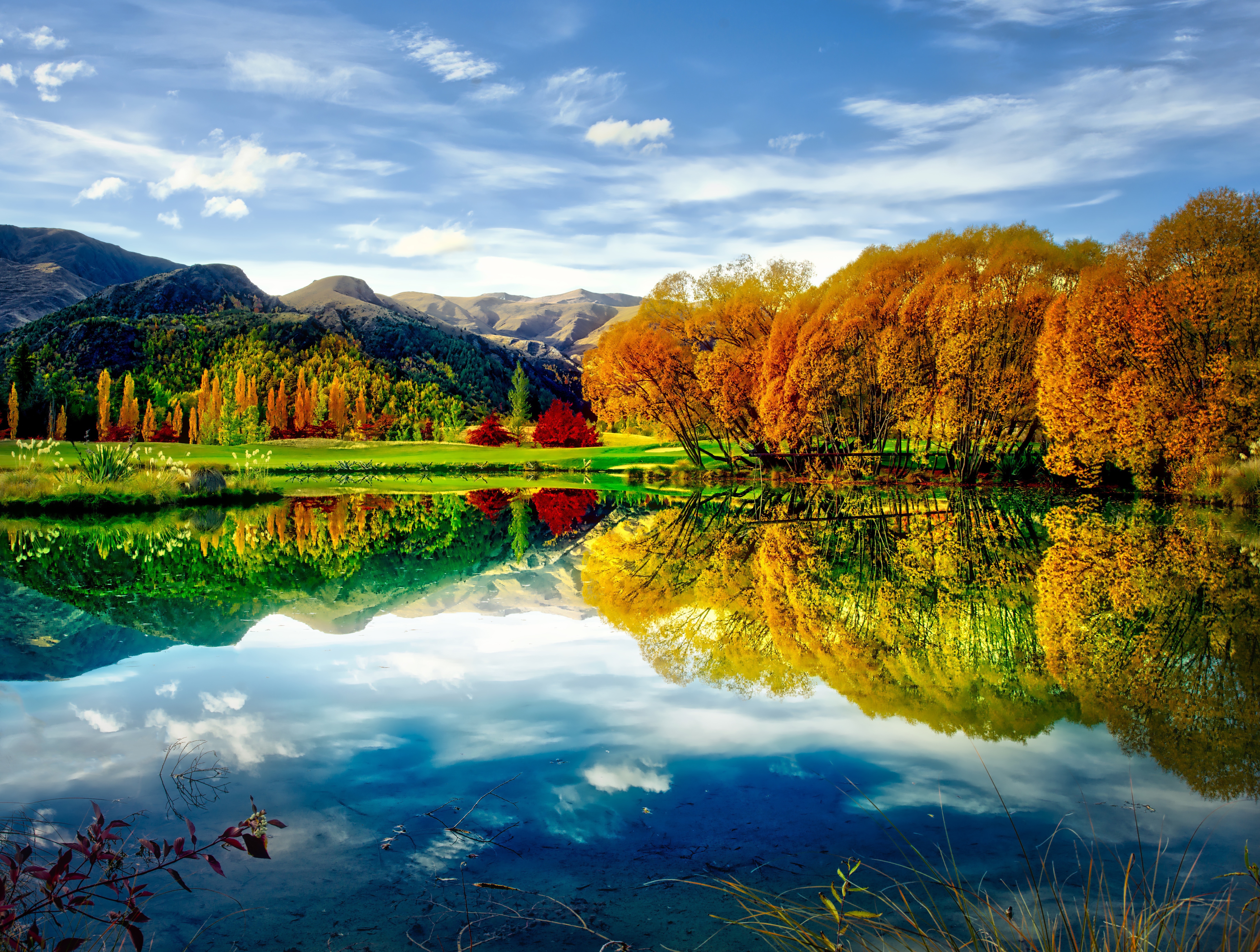 Autumn trees reflected in a lake with mountains HD Wallpaper