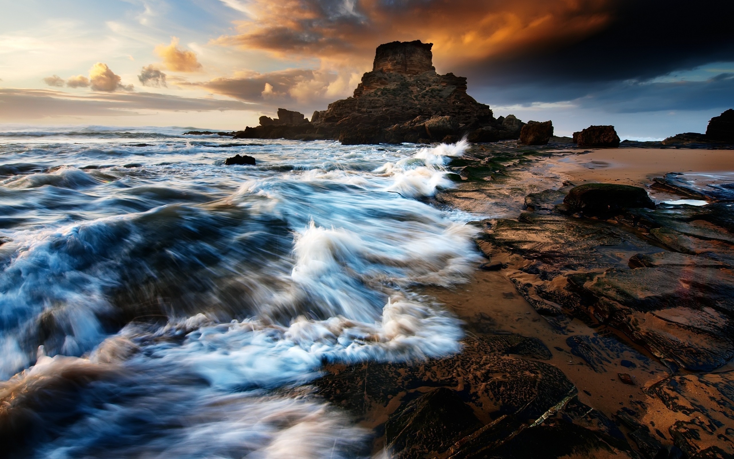 Waves crashing on rocky shore at sunset HD Wallpaper
