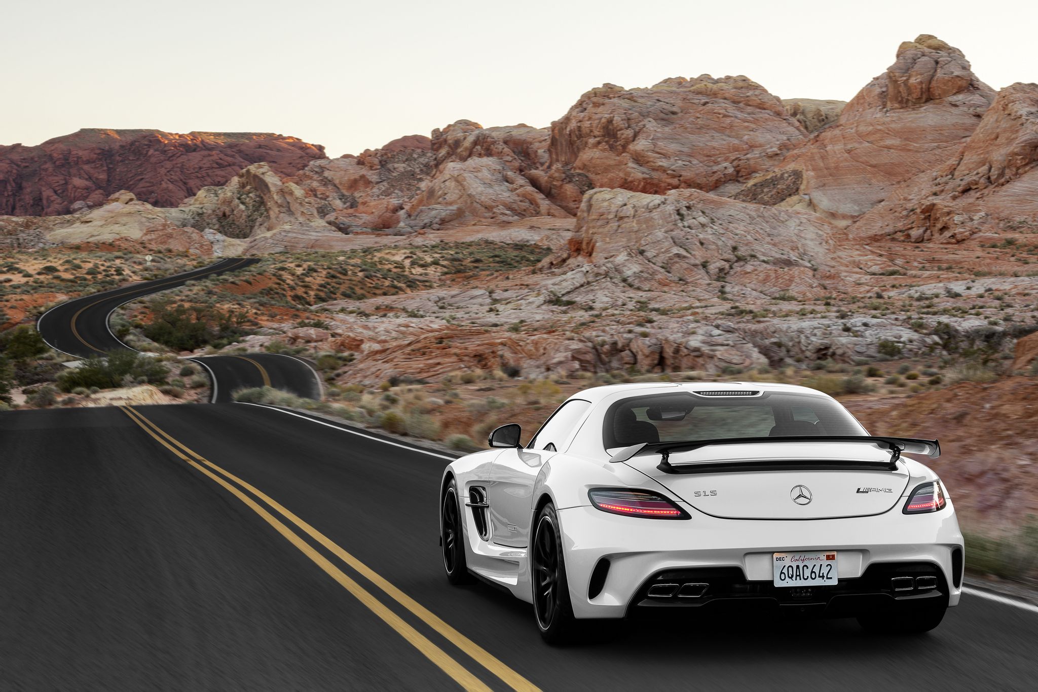 White Mercedes SLS AMG driving on a desert road HD Wallpaper