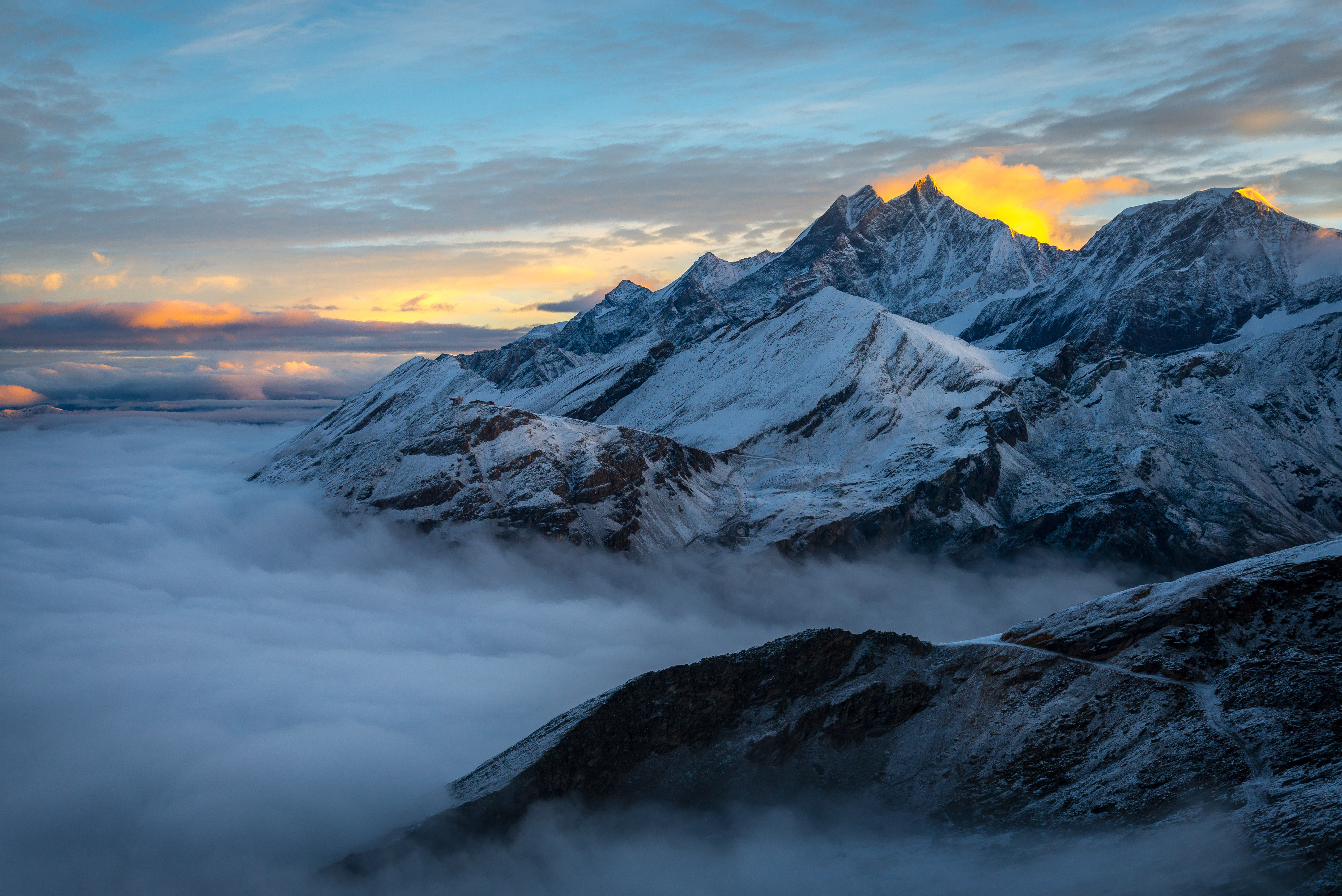 Snowy mountain peaks above clouds at sunrise, Alps, Switzerland HD Wallpaper