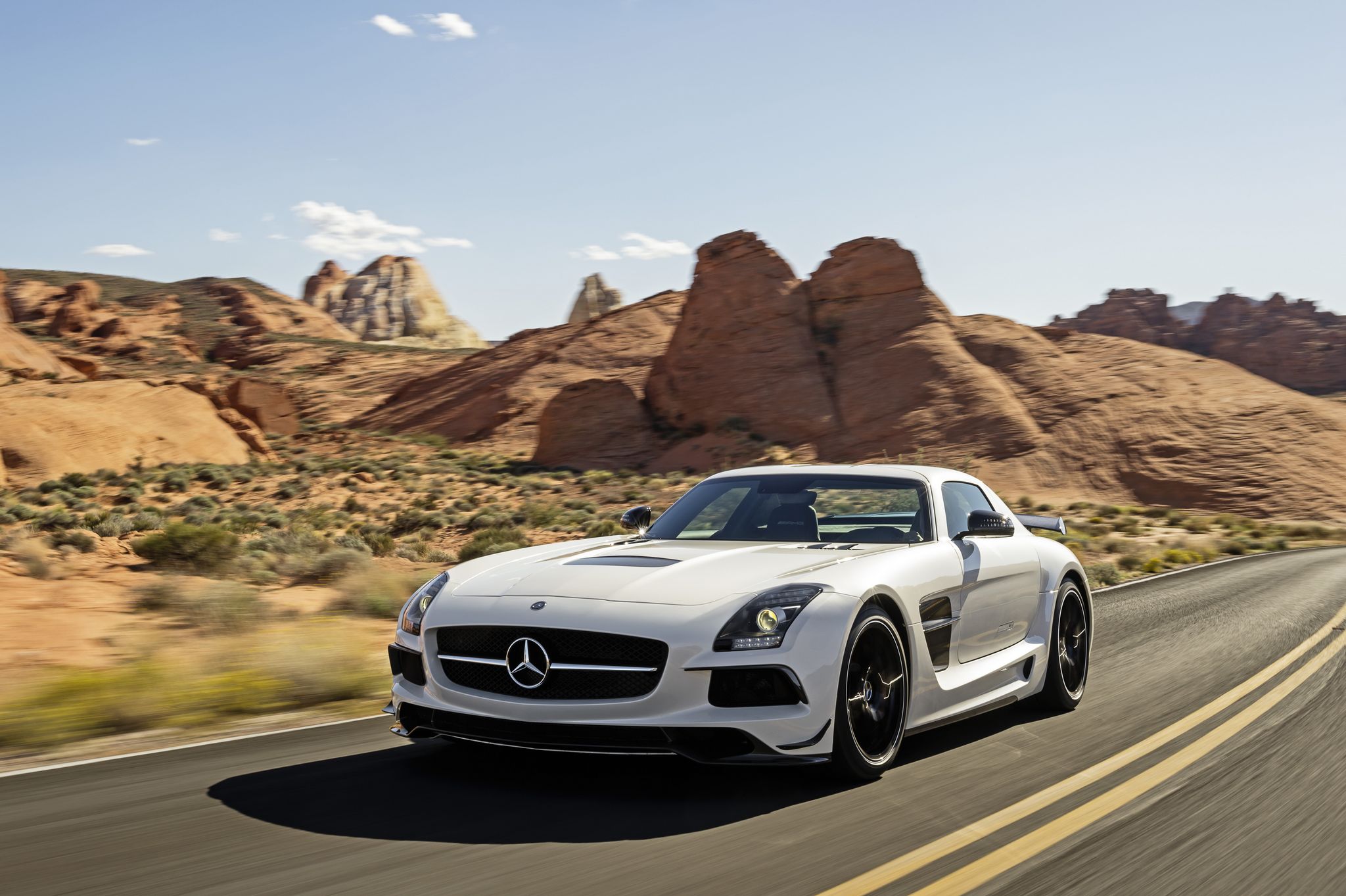 White Mercedes SLS AMG GT driving on a desert road HD Wallpaper