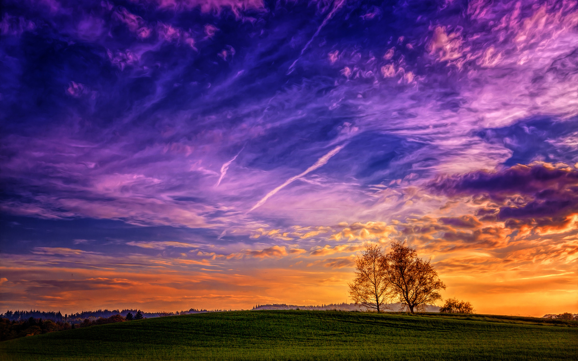 Dramatic sunset over rolling green hills with trees HD Wallpaper