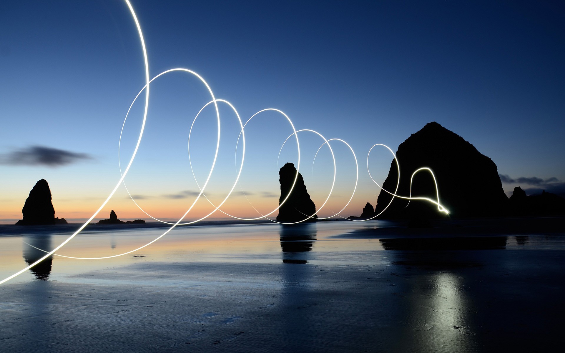 Light trails over beach rocks at sunset HD Wallpaper