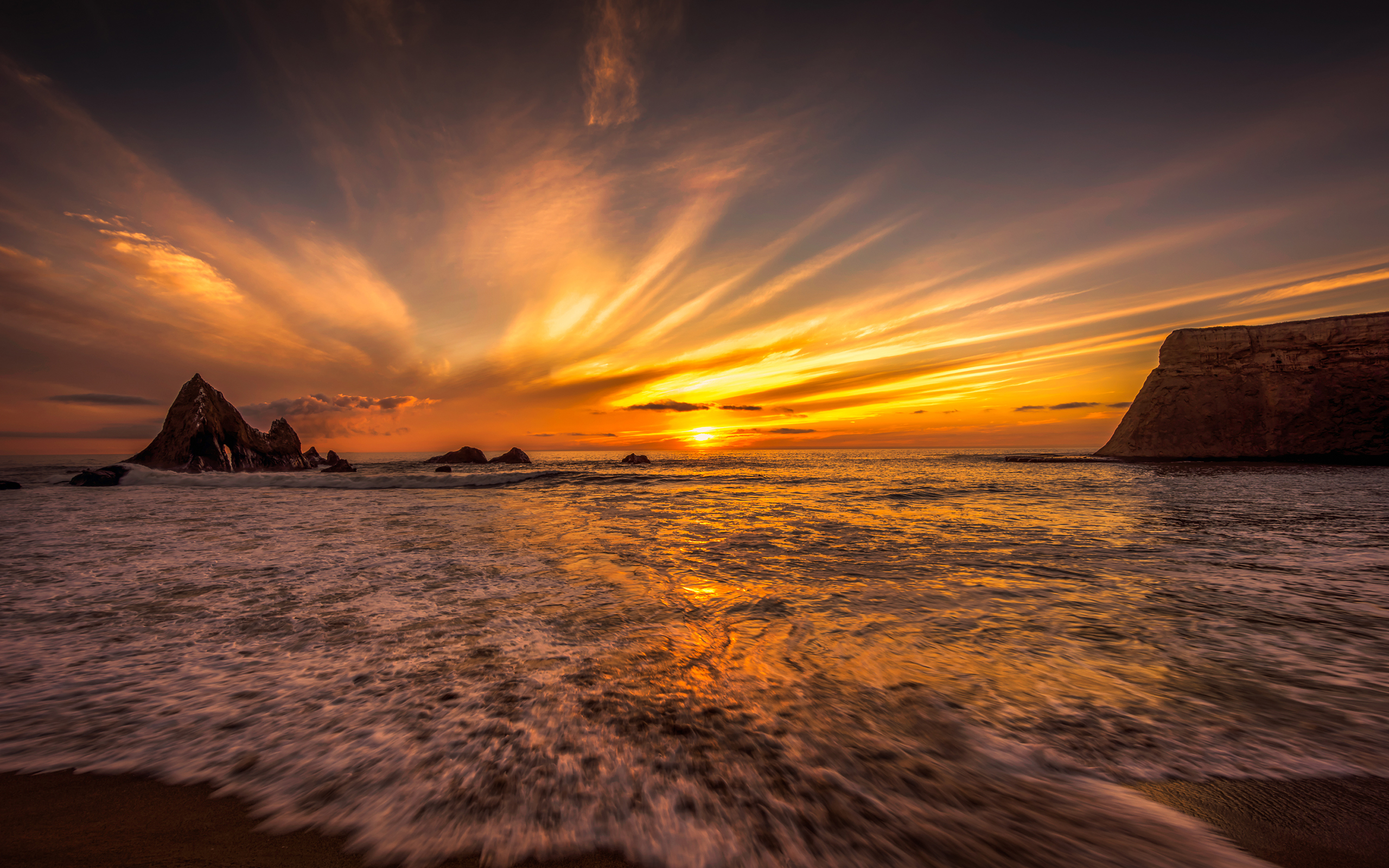 Sunset over the ocean with rock formations HD Wallpaper