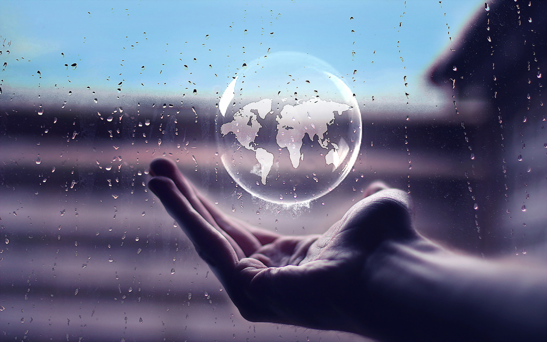World map in a bubble held by a hand HD Wallpaper