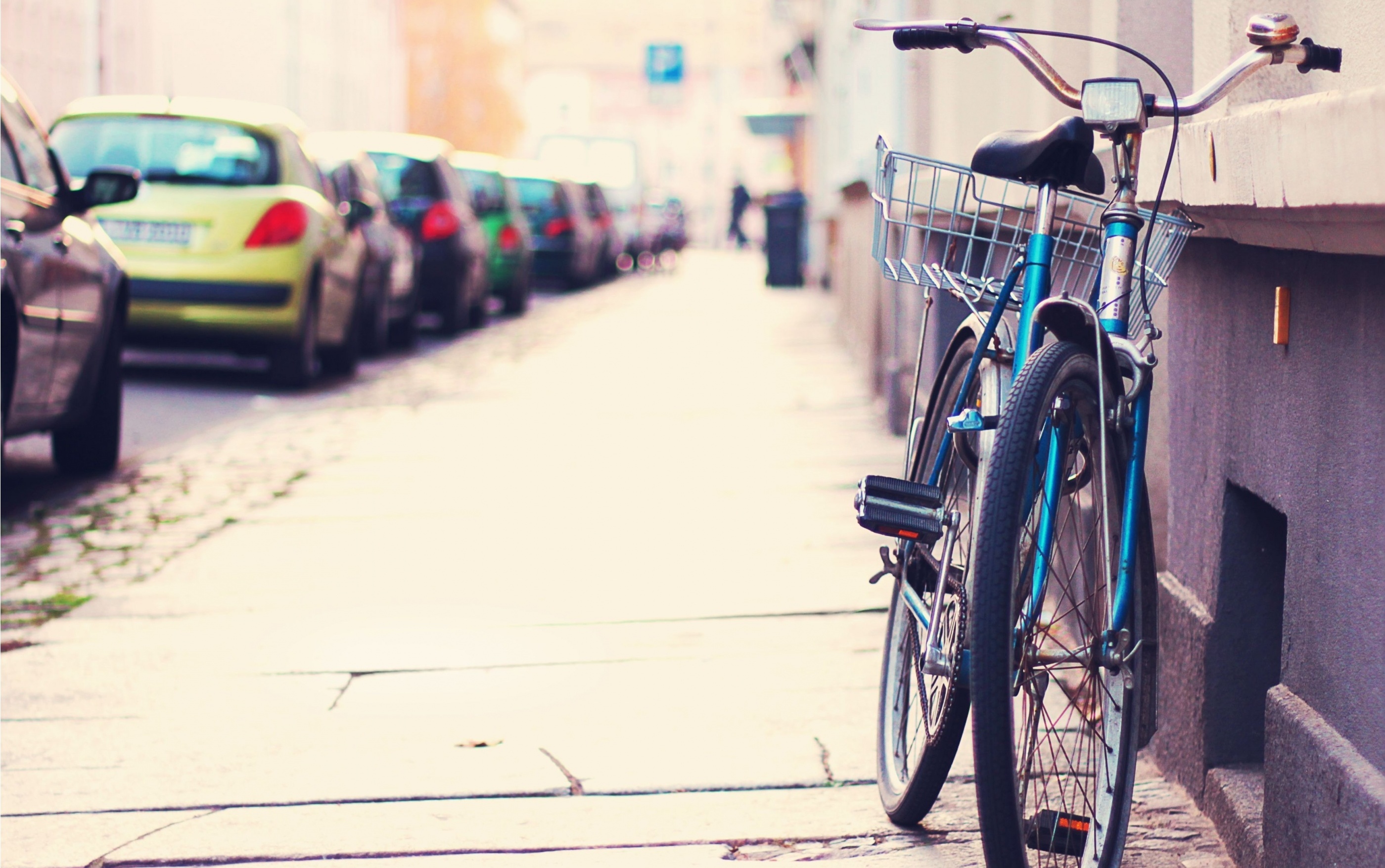 Blue bicycle parked on a street with cars HD Wallpaper
