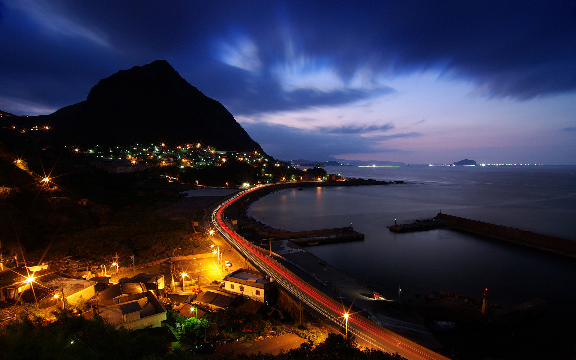 Coastal town at night with mountain and sea HD Wallpaper