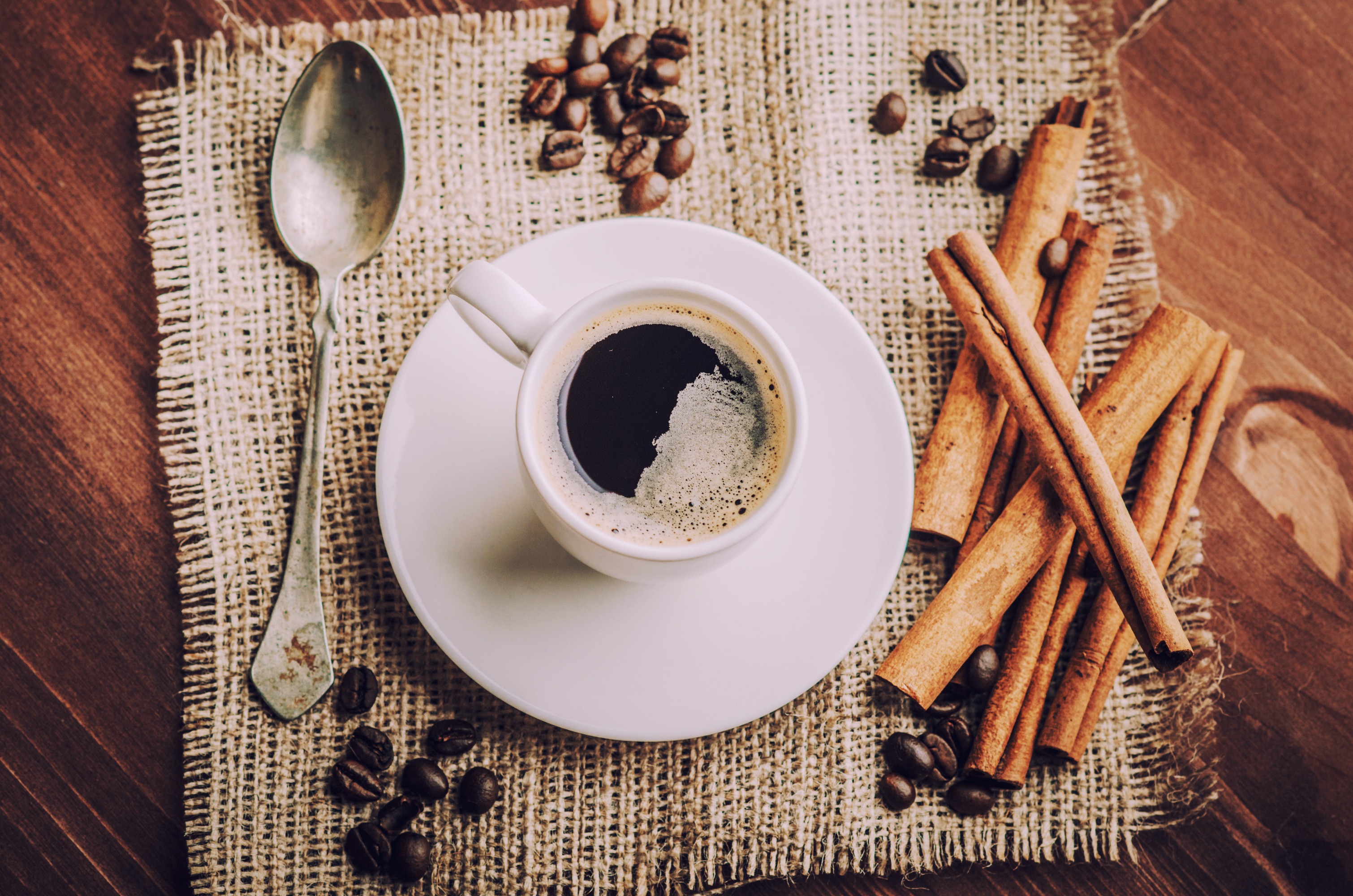 Coffee cup with cinnamon sticks and coffee beans HD Wallpaper