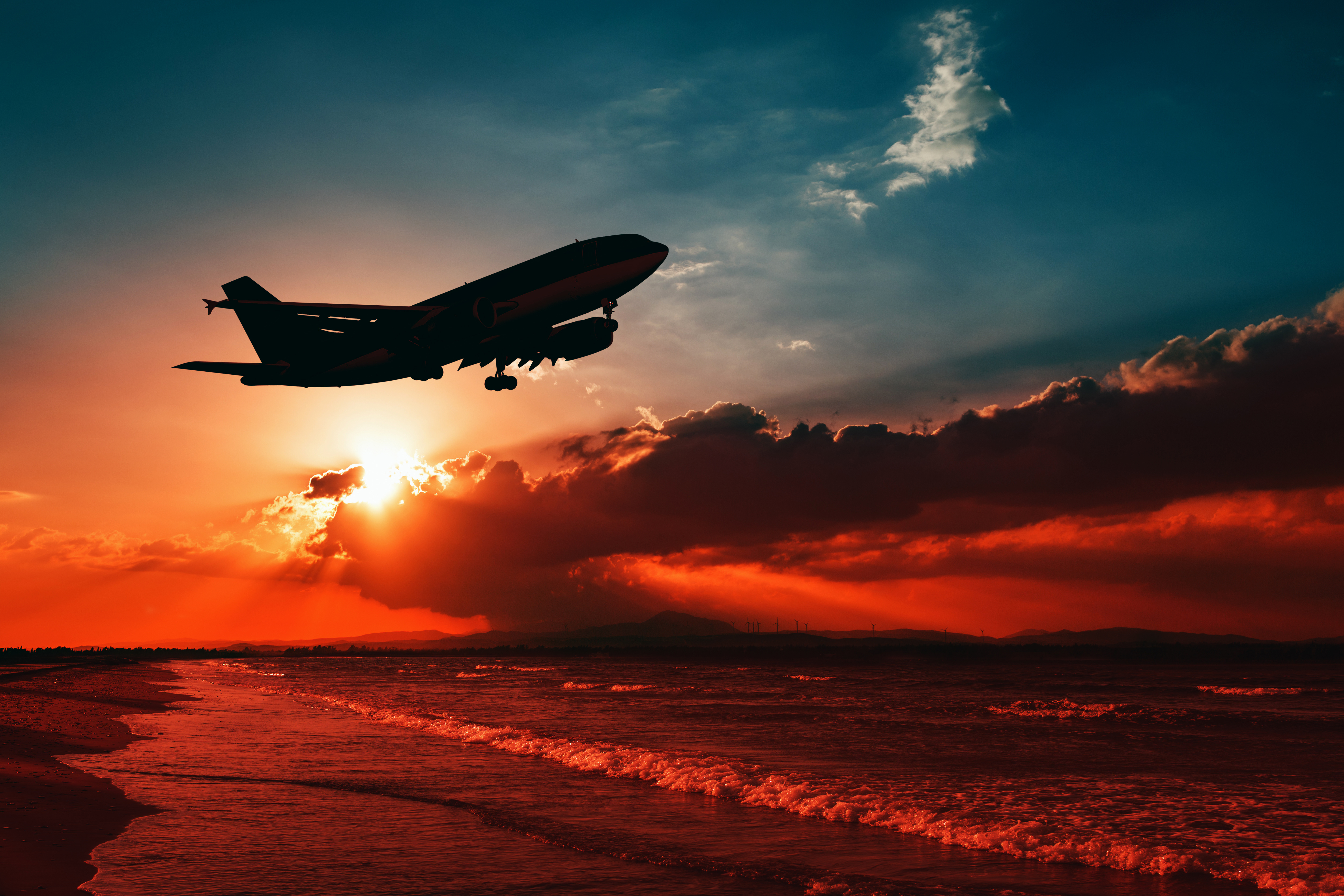 Airplane taking off over the ocean at sunset HD Wallpaper