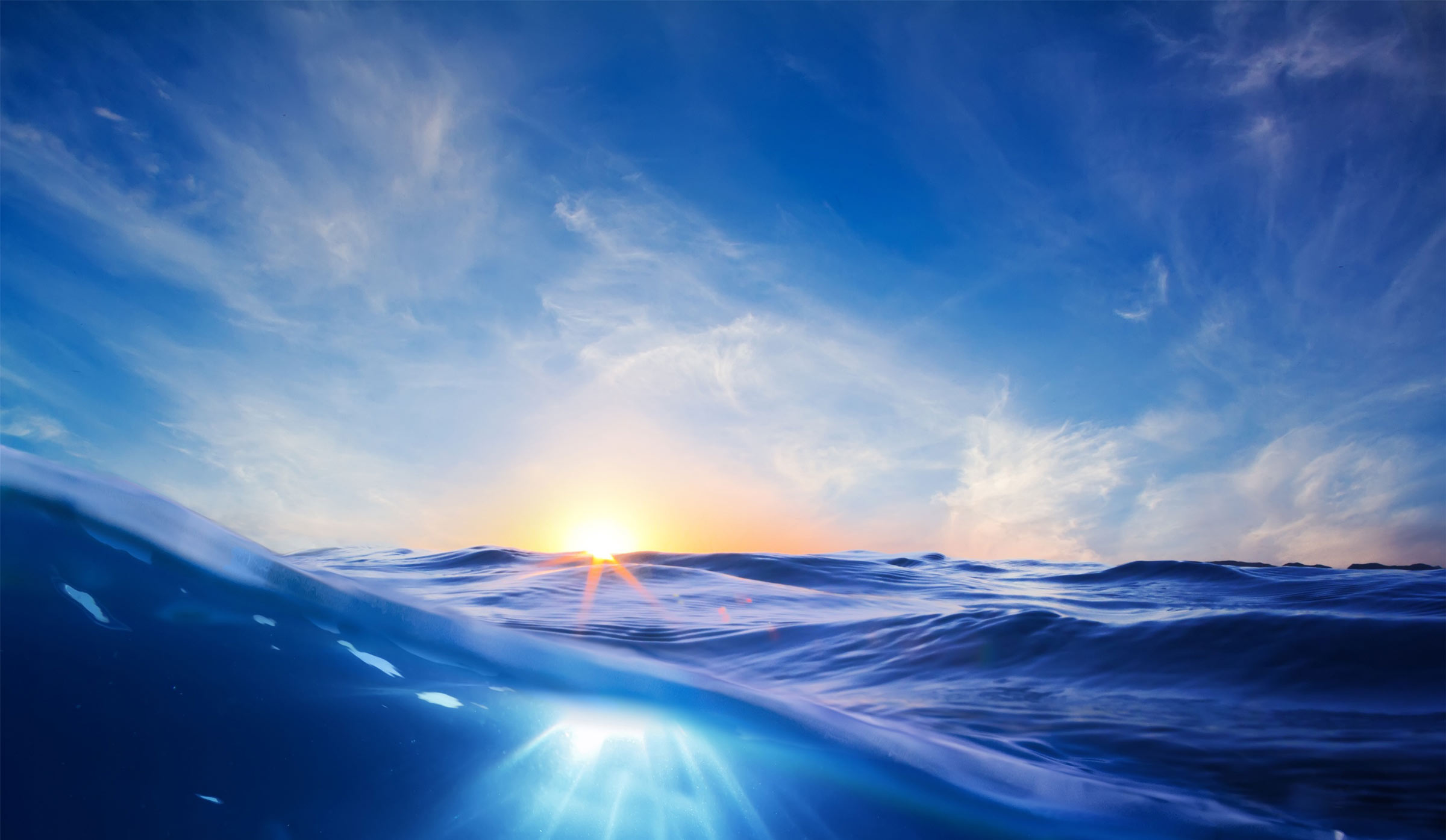 Ocean waves under a blue sky with a sunset HD Wallpaper