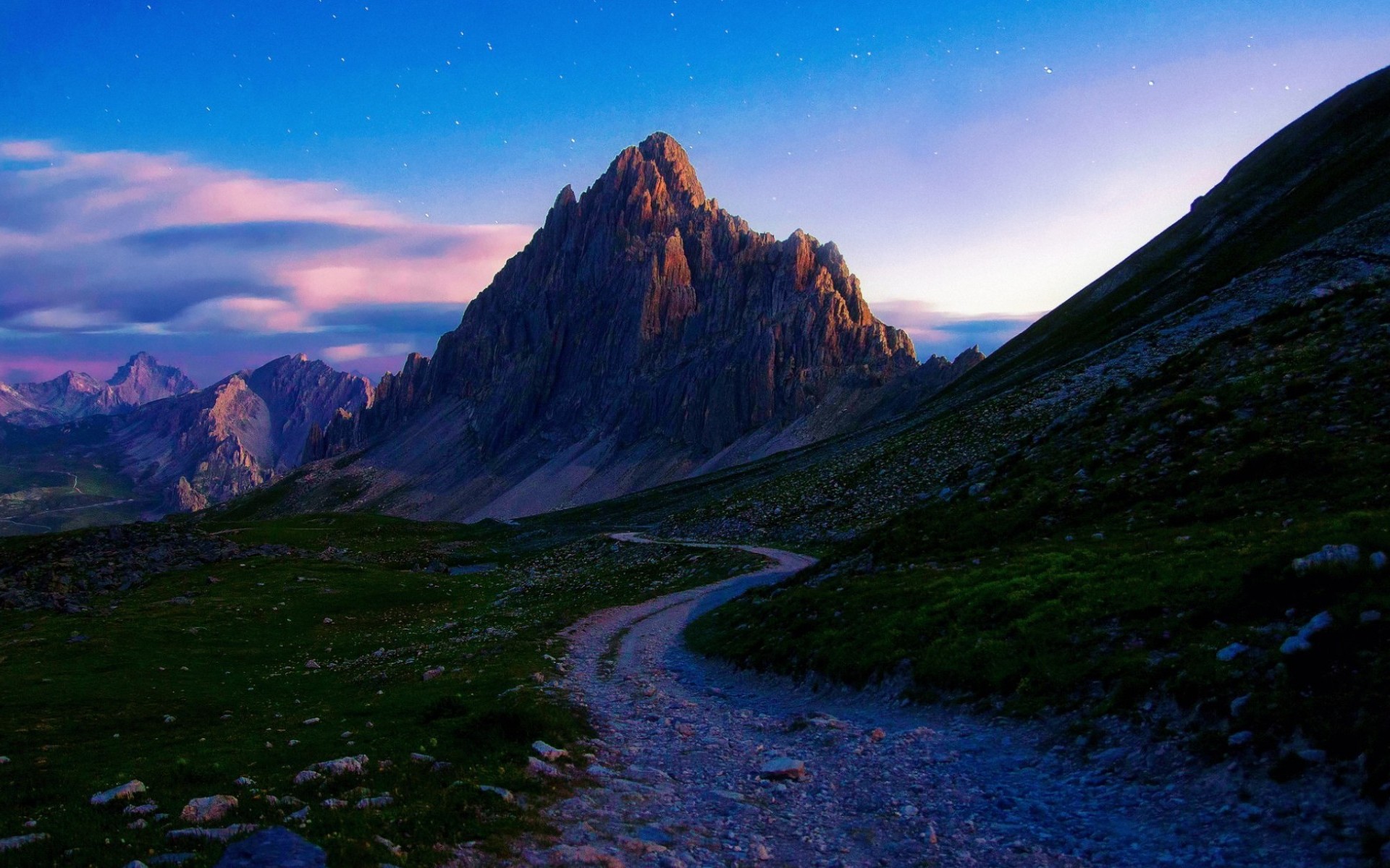 Mountain ridge with a winding road at dusk HD Wallpaper