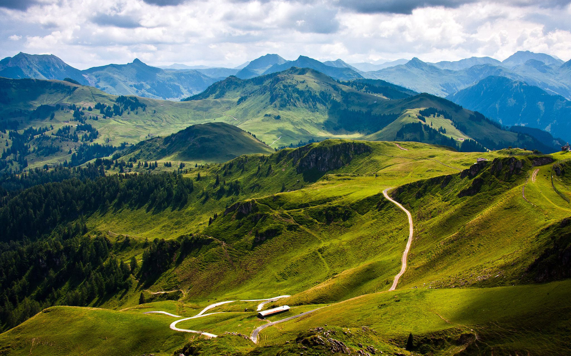 Mountain landscape with winding roads and green hills HD Wallpaper