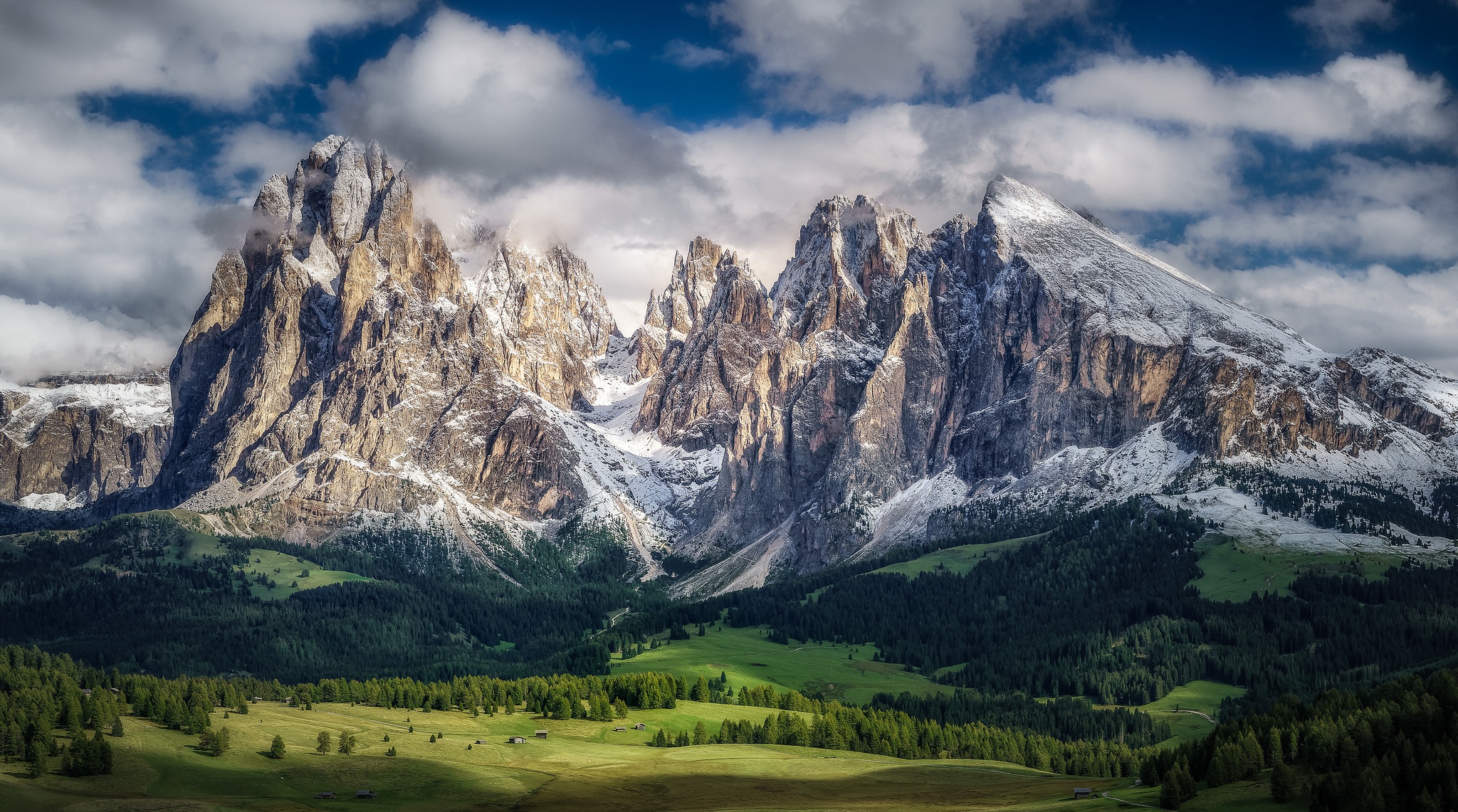 Snow-capped mountains under a cloudy sky HD Wallpaper