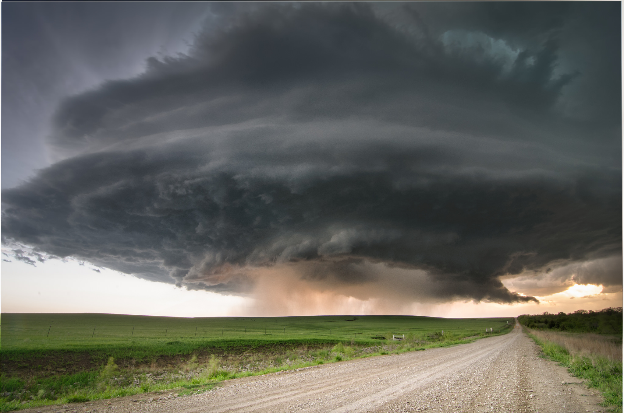 Storm clouds over a rural landscape with a dirt road HD Wallpaper