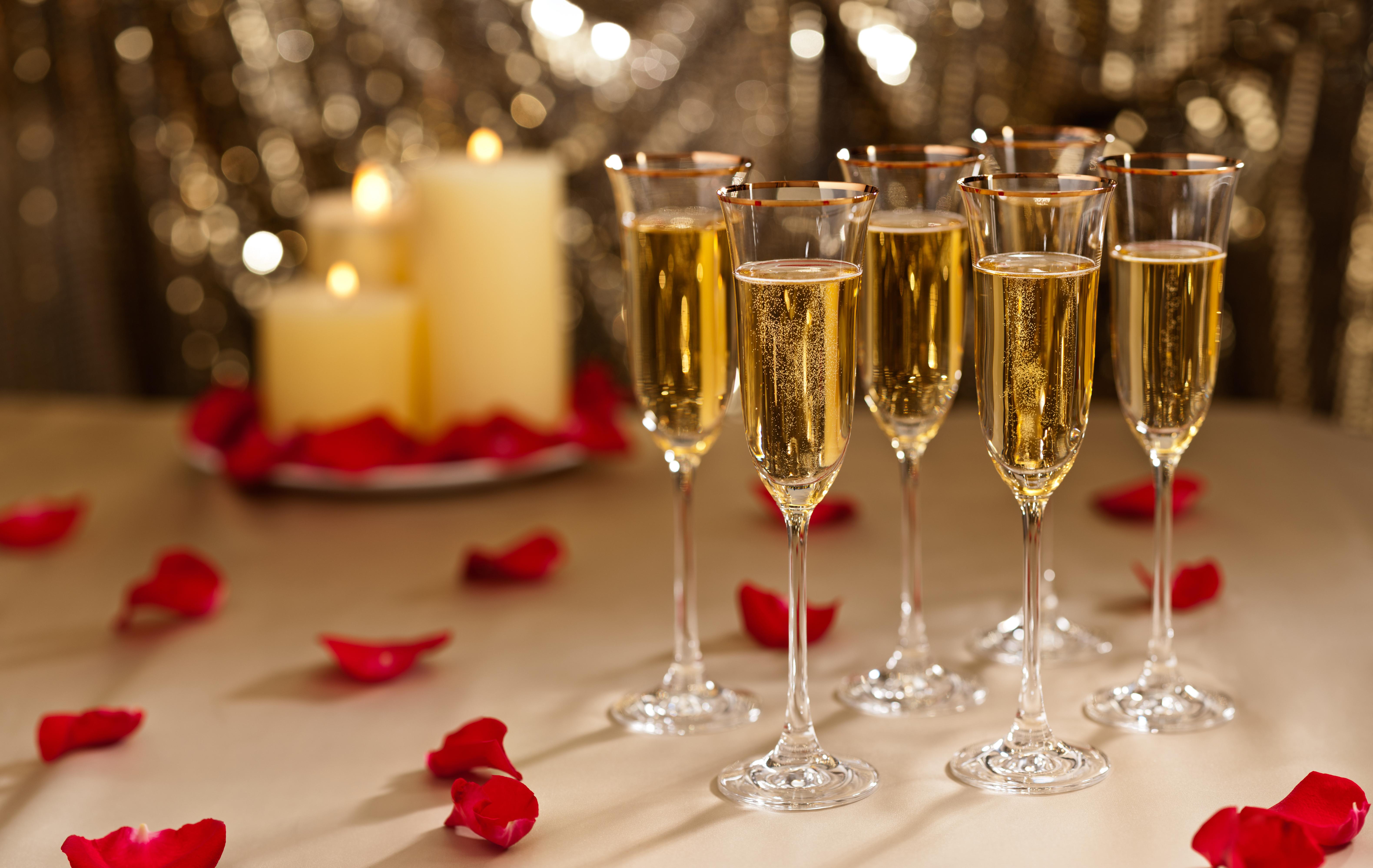 Champagne glasses with candles and rose petals HD Wallpaper
