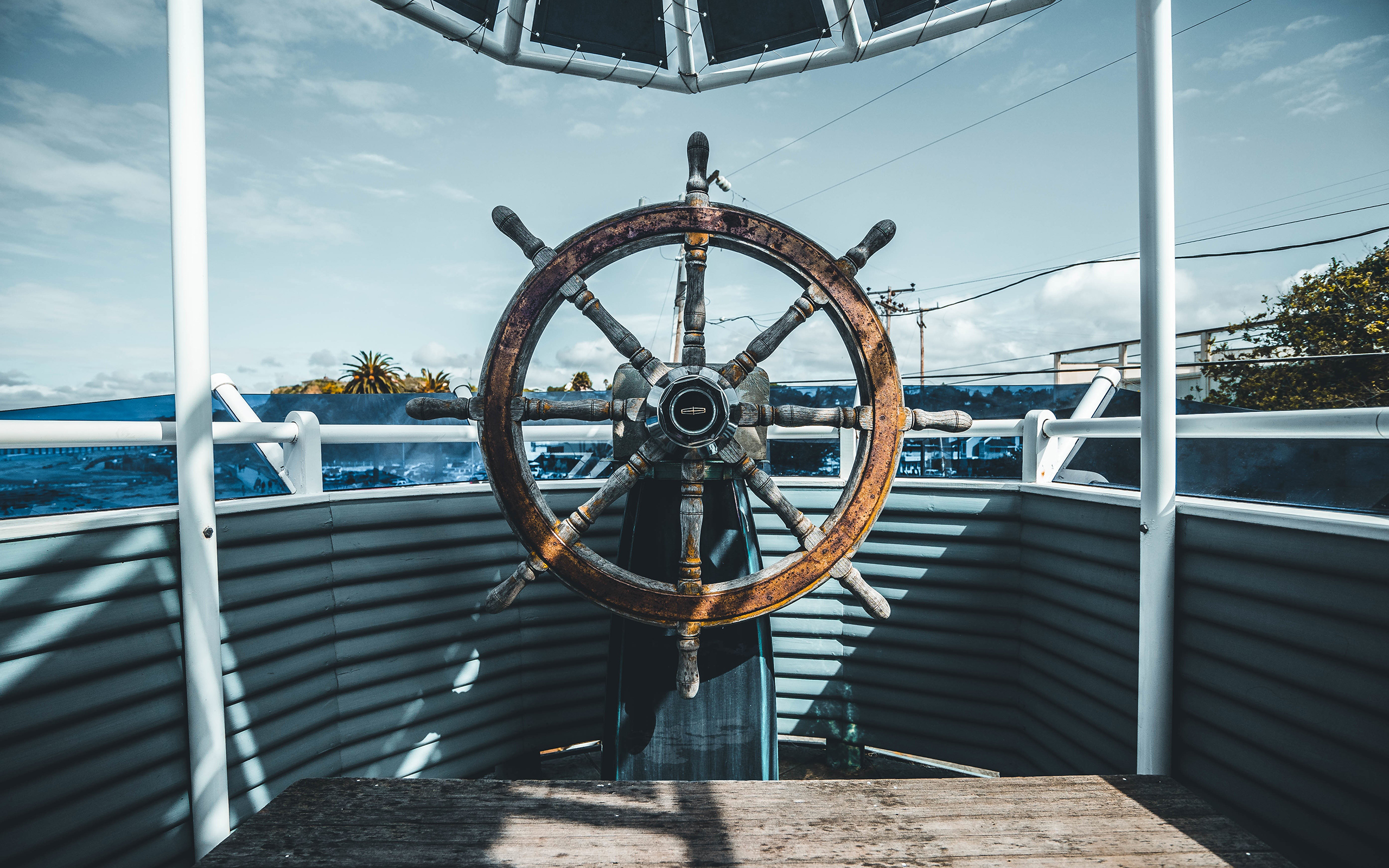 Ship's steering wheel on a deck HD Wallpaper