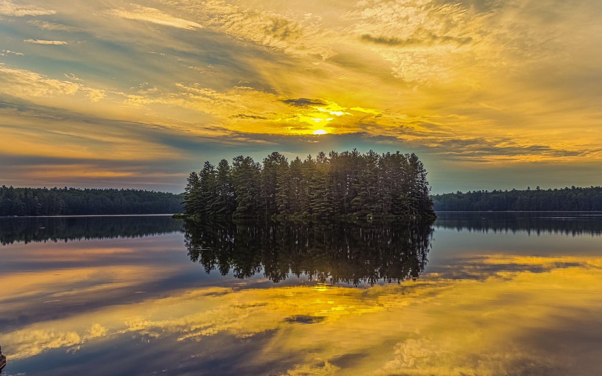 Island with trees reflected in a lake at sunset HD Wallpaper