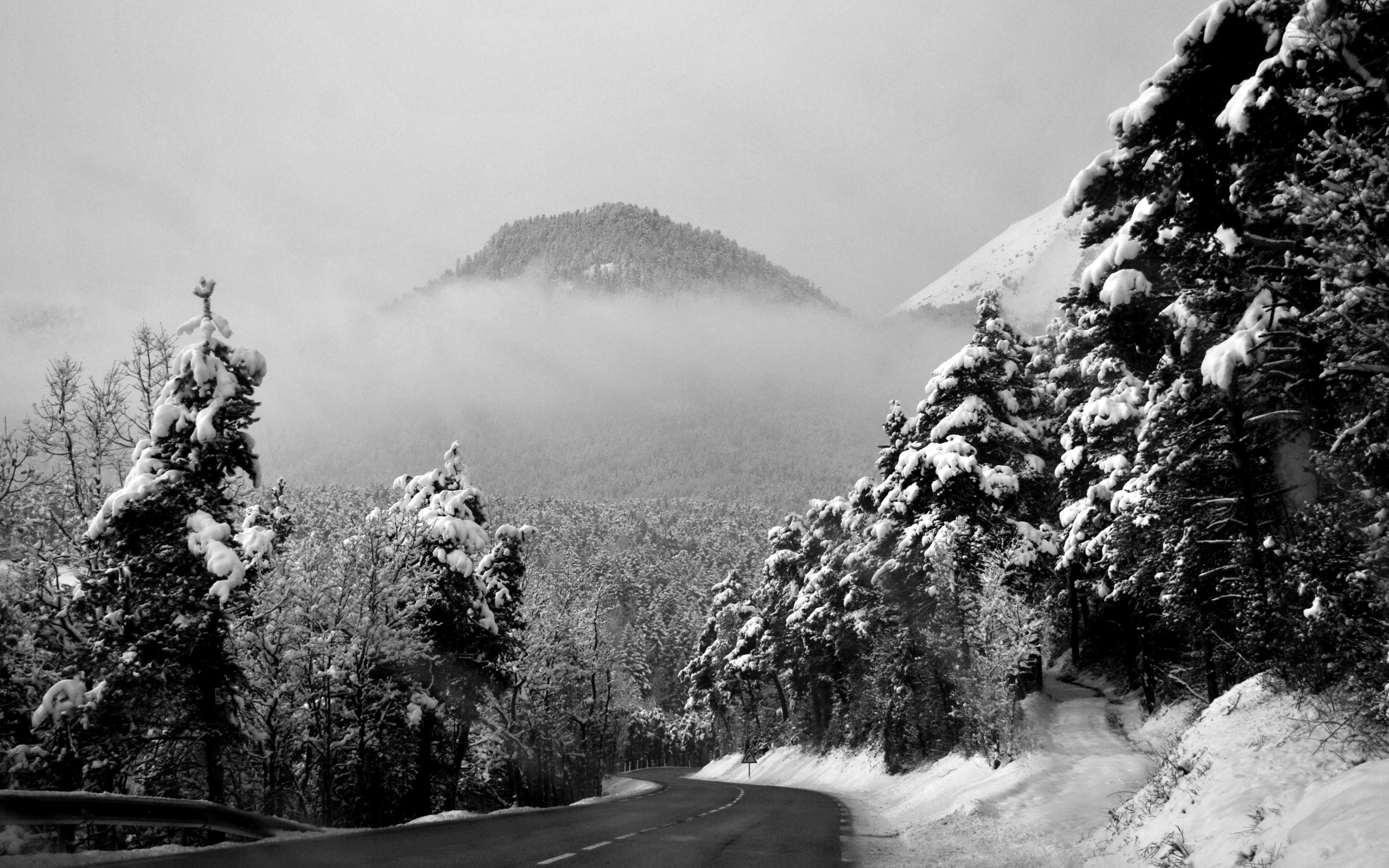 Black and white photography of a snowy mountain road HD Wallpaper