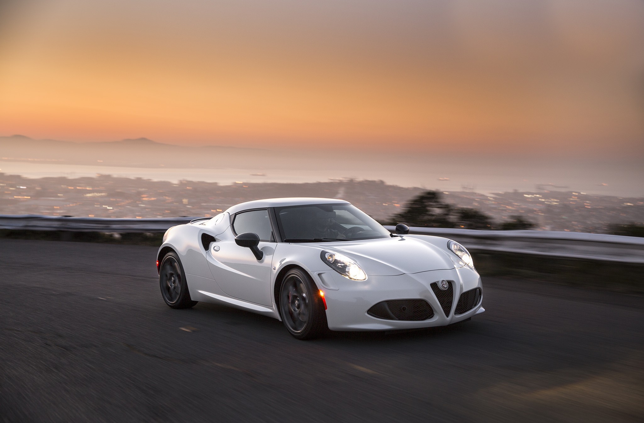 White Alfa Romeo 4C driving on a road at sunset HD Wallpaper