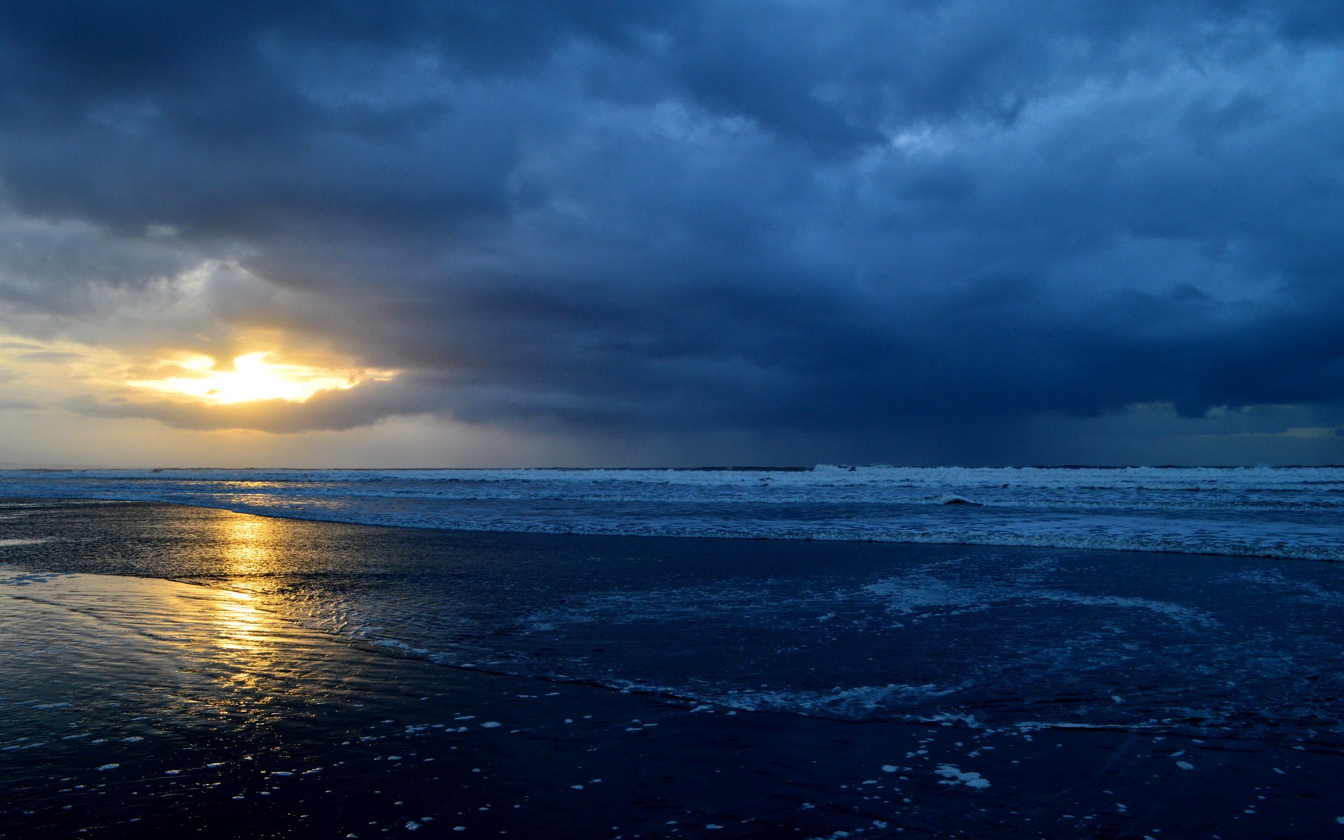 Sunset over a stormy beach with waves HD Wallpaper