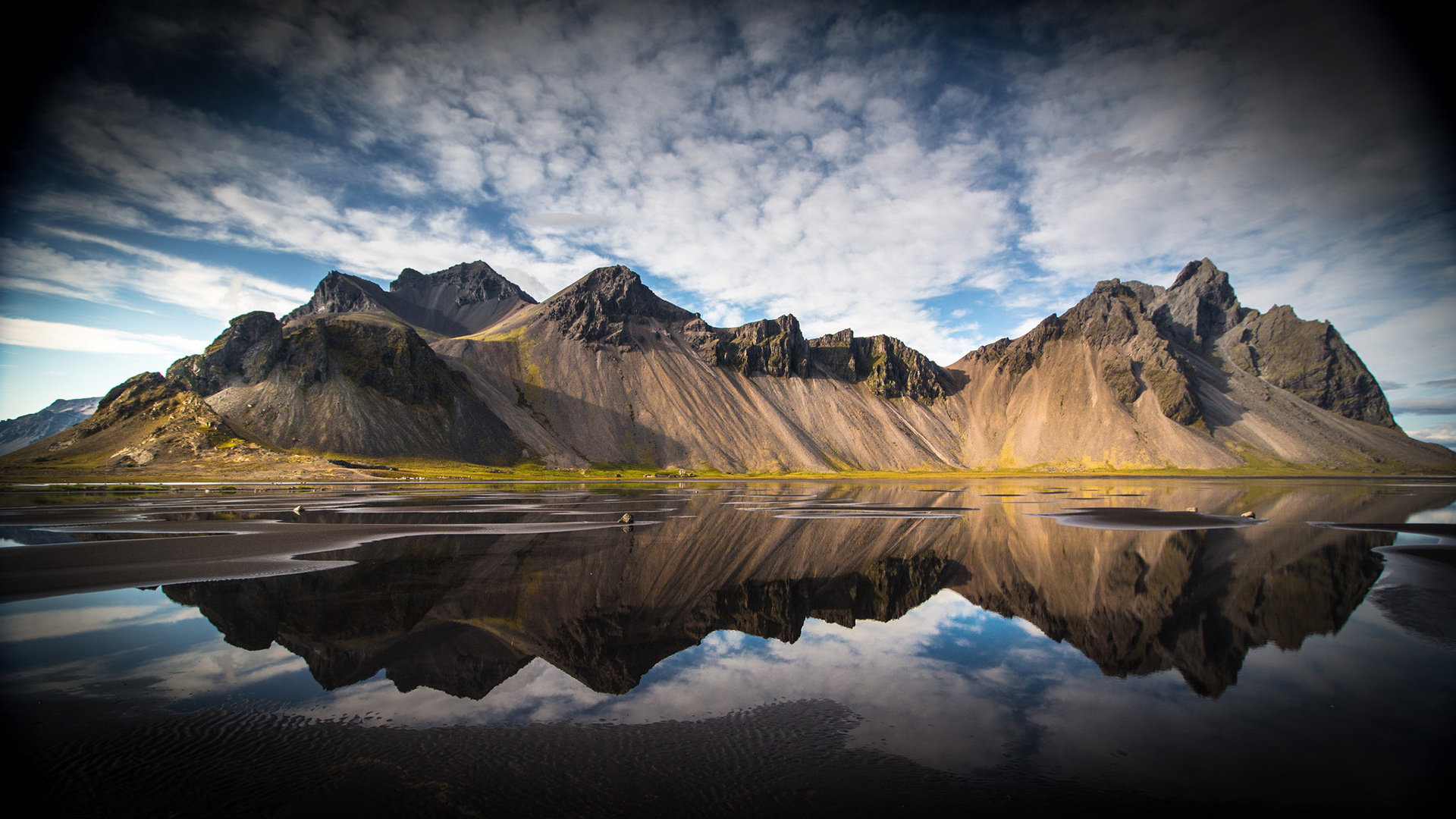 Mountain range reflected in water under cloudy sky HD Wallpaper