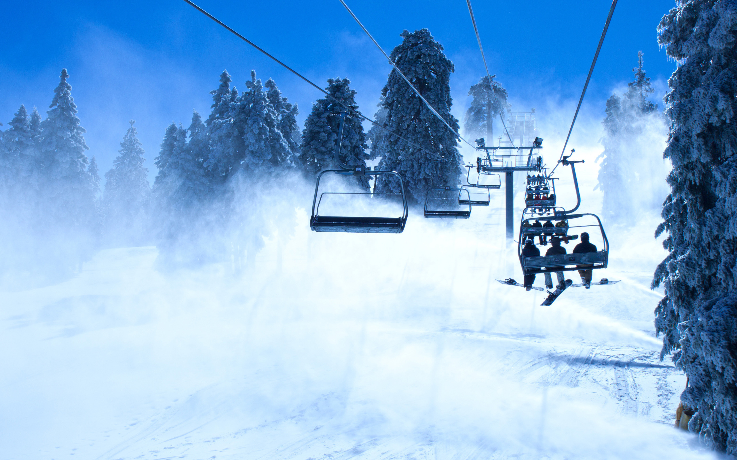 Ski lift in a snowy forest HD Wallpaper