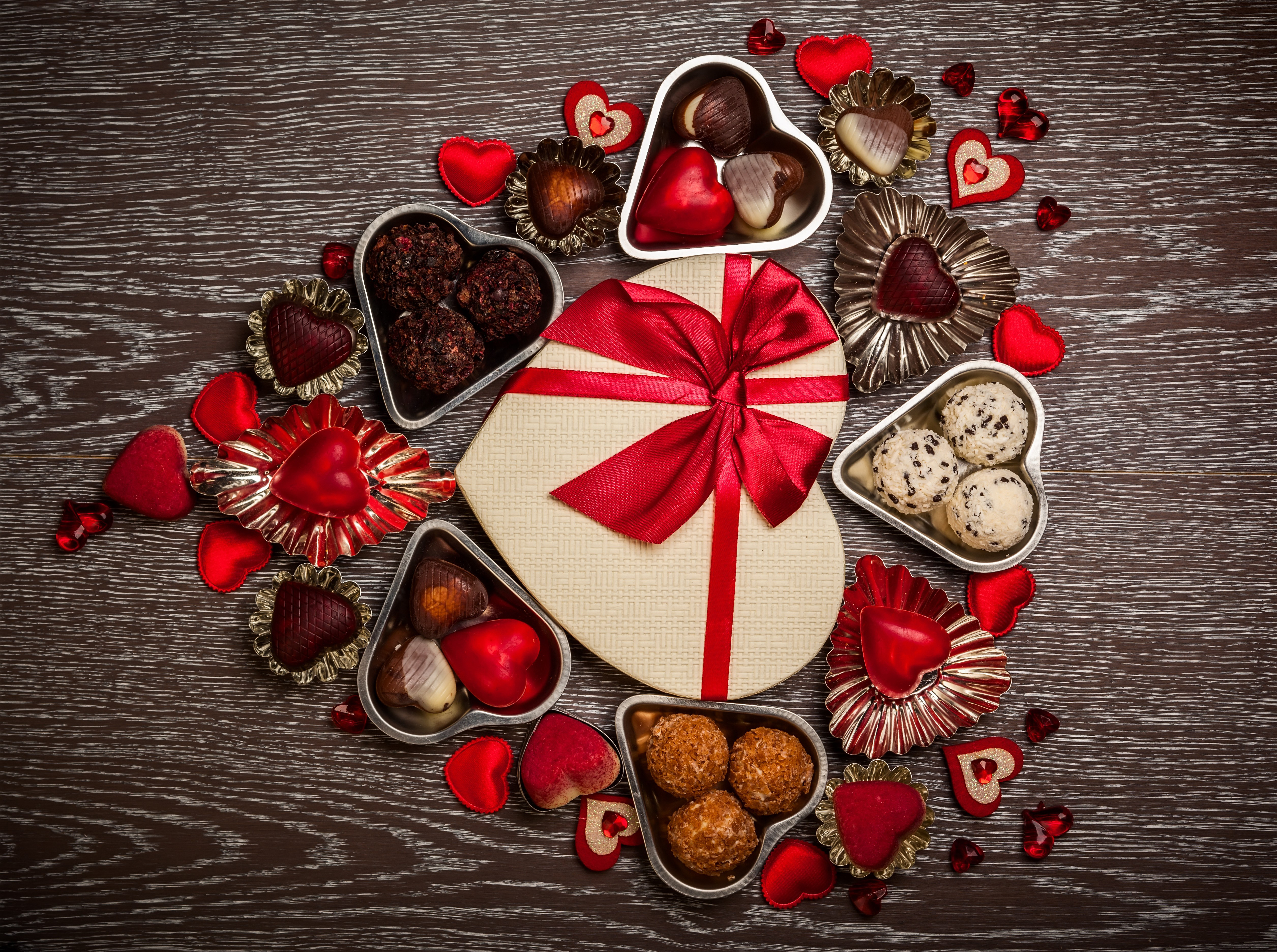 Heart-shaped box of chocolates with red ribbon and decorations HD Wallpaper