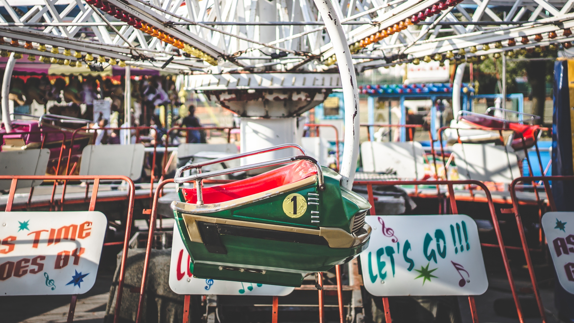 Amusement park ride with colorful seats and signs HD Wallpaper
