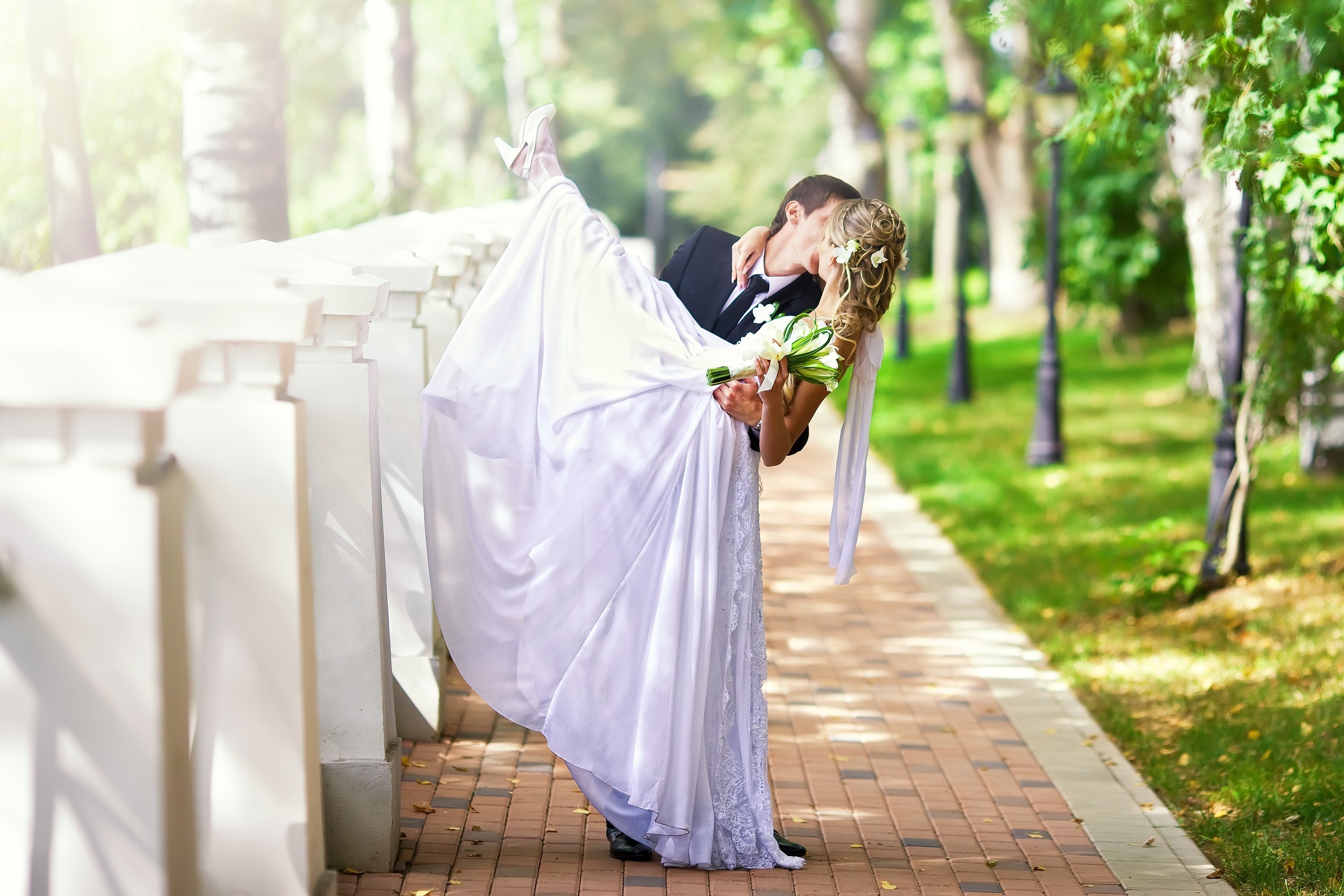 Groom carrying bride in park HD Wallpaper