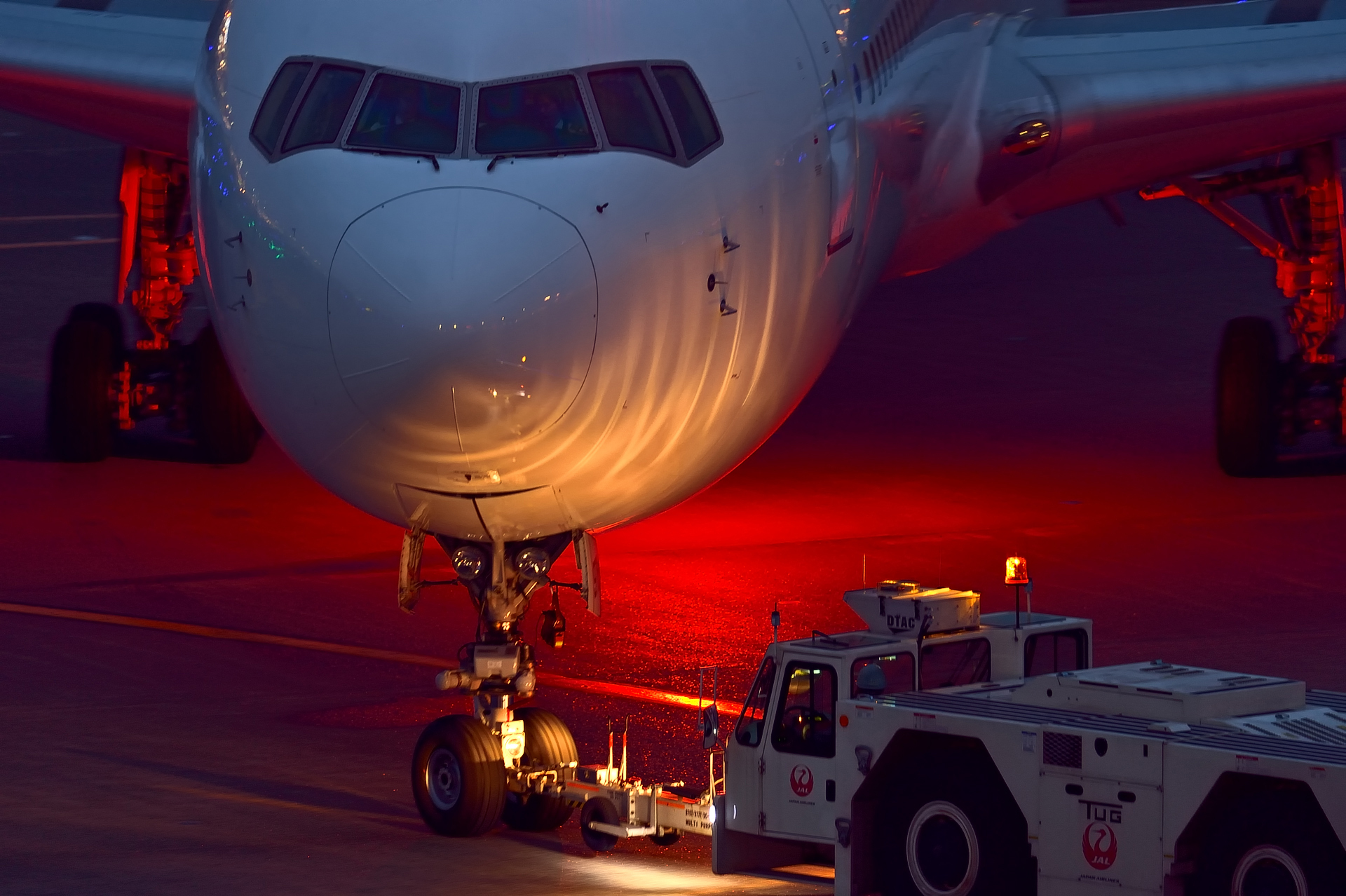 Airplane being towed at airport at night HD Wallpaper