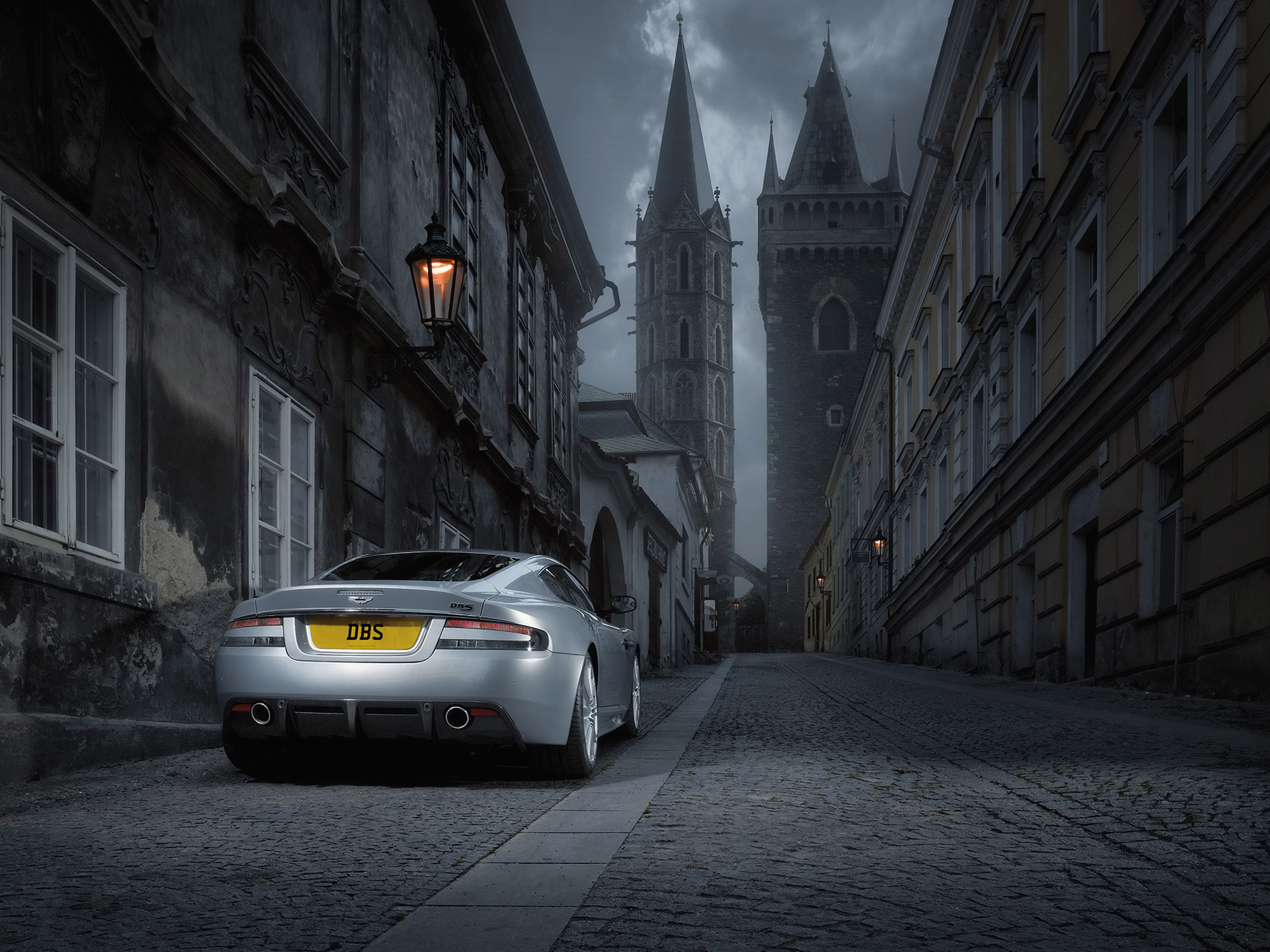 Aston Martin DBS on a cobblestone street HD Wallpaper